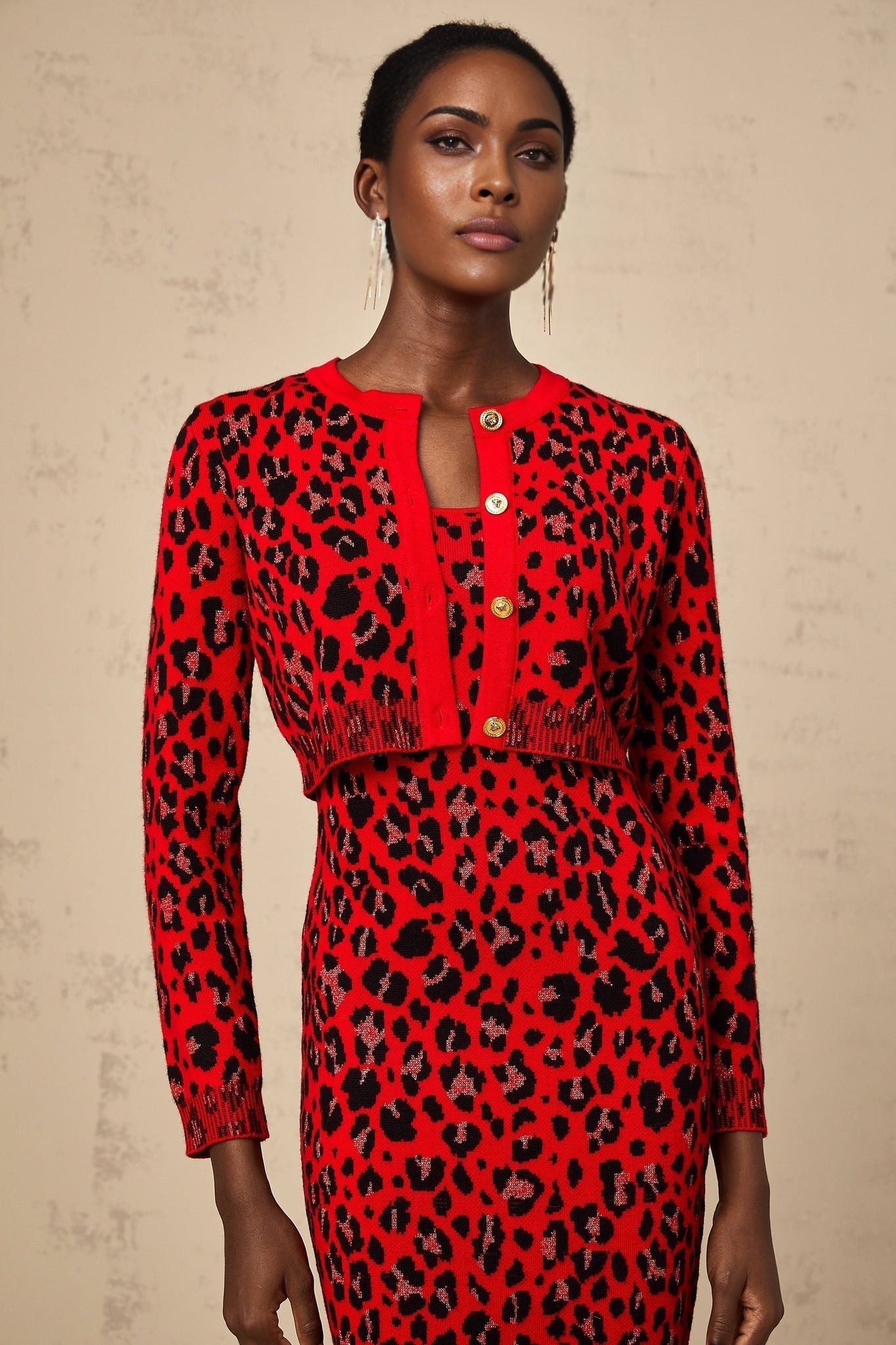 A red leopard print cardigan with a shimmery lurex fabric blend worn open over a dark top