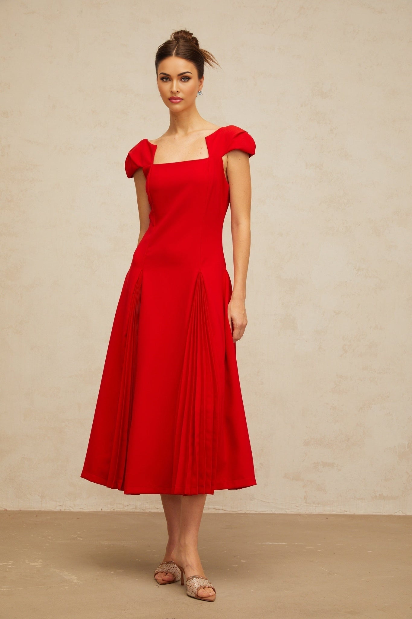 A red midi dress with a flared skirt and pleated details named Gervaise