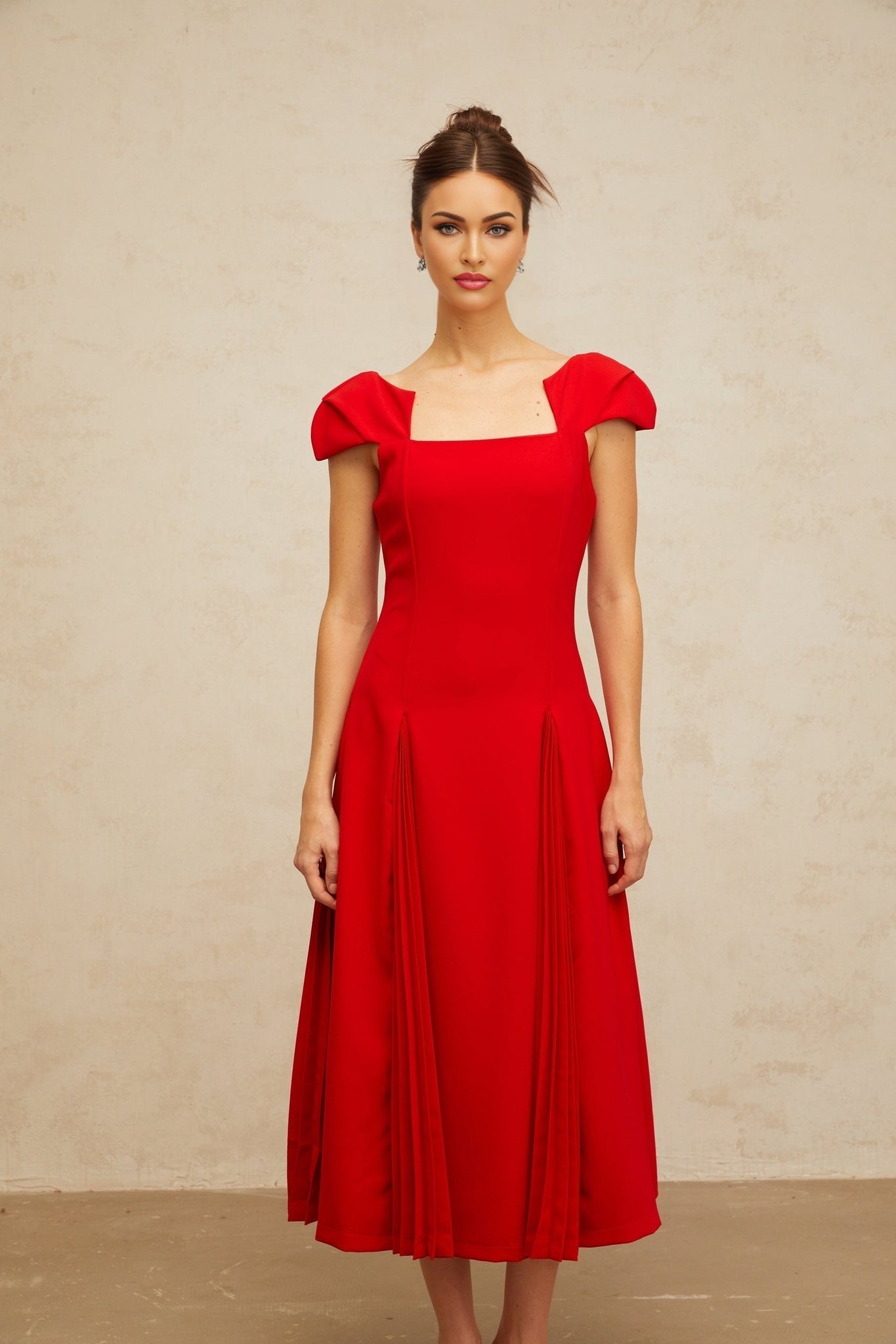 A red midi dress with a flared skirt and pleated details named Gervaise