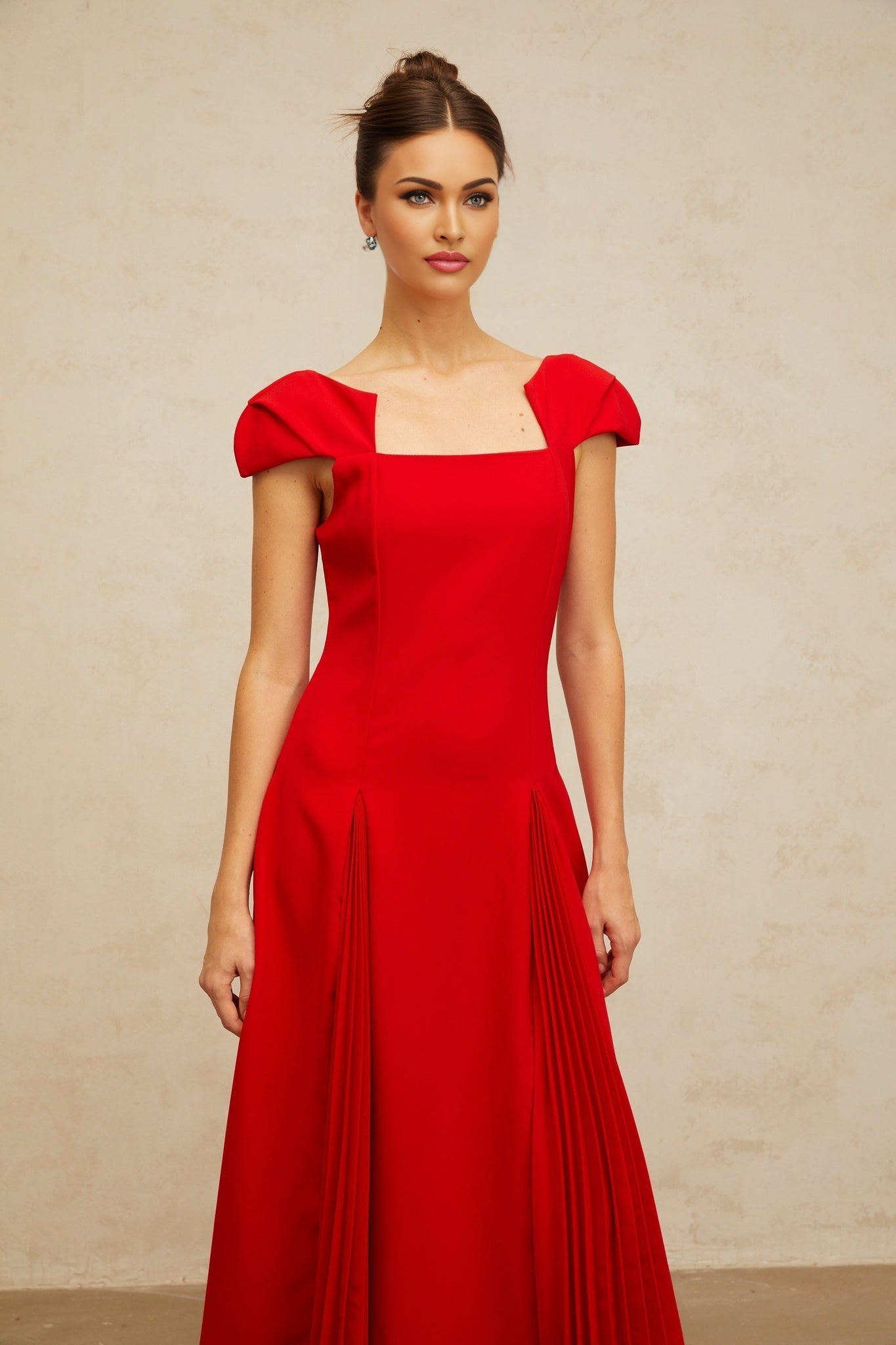 A red midi dress with a flared skirt featuring pleated details named Gervaise