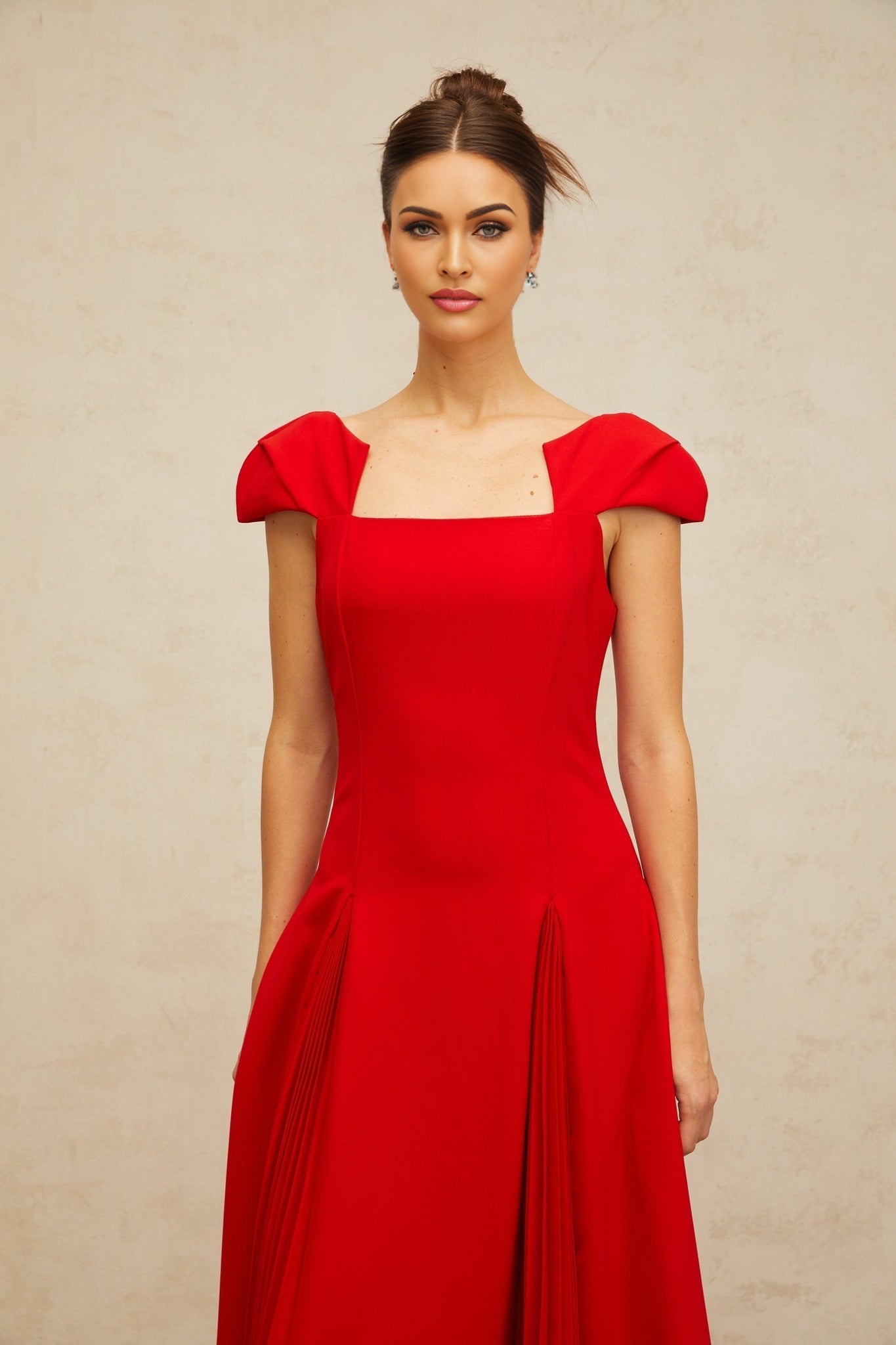 A red midi dress with pleated details and a flared silhouette