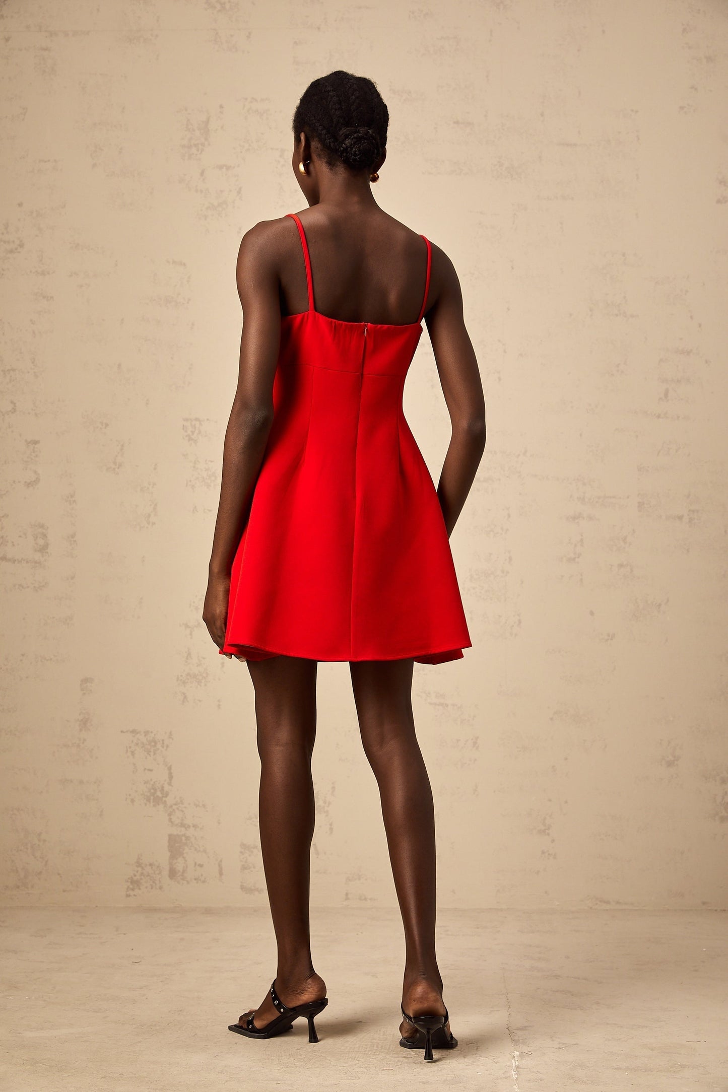 A red mini dress with a flared skirt featuring rose appliqués and a fitted bodice