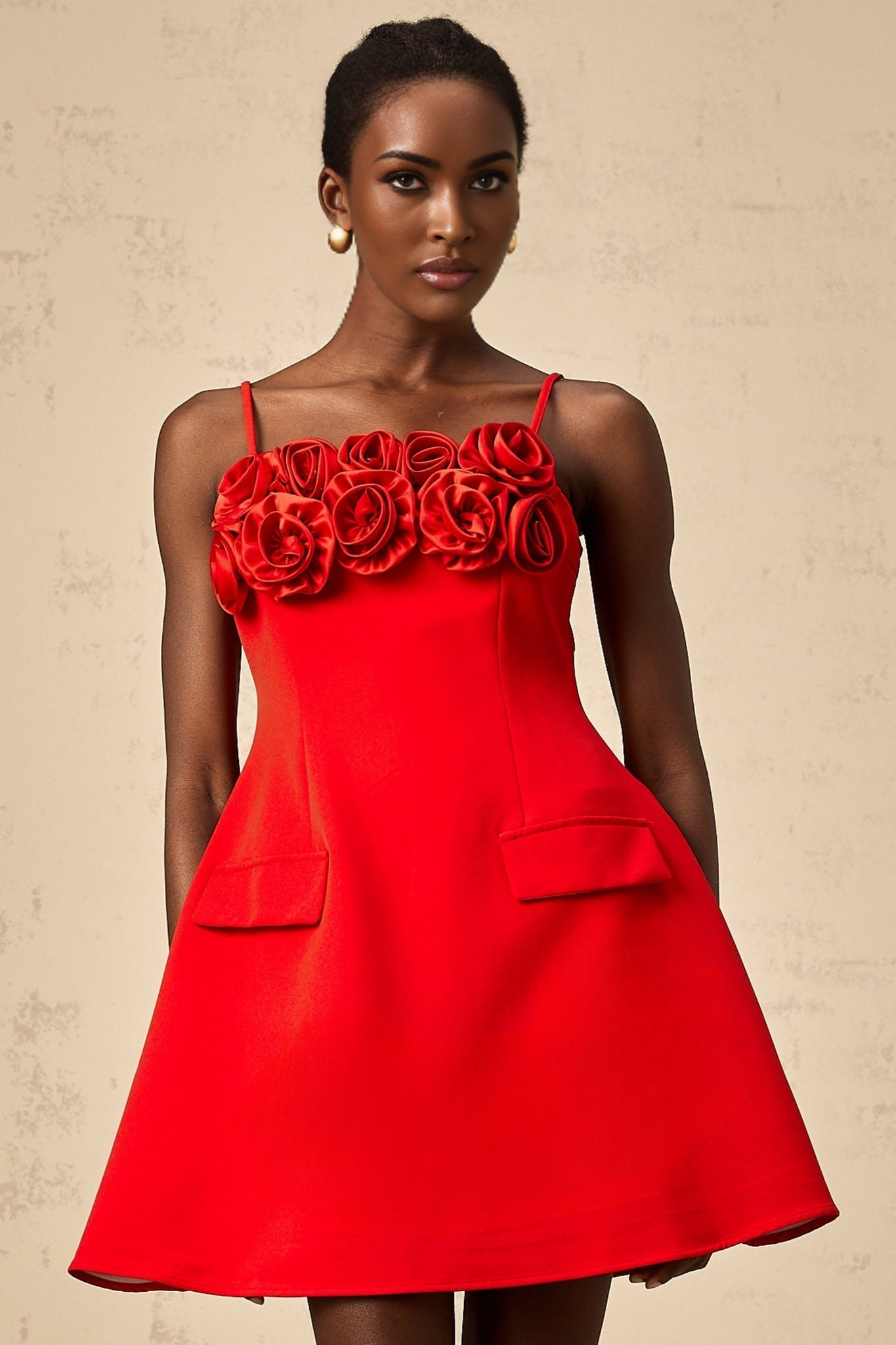 A red mini dress with a flared skirt featuring rose appliqués short sleeves and a fitted bodice