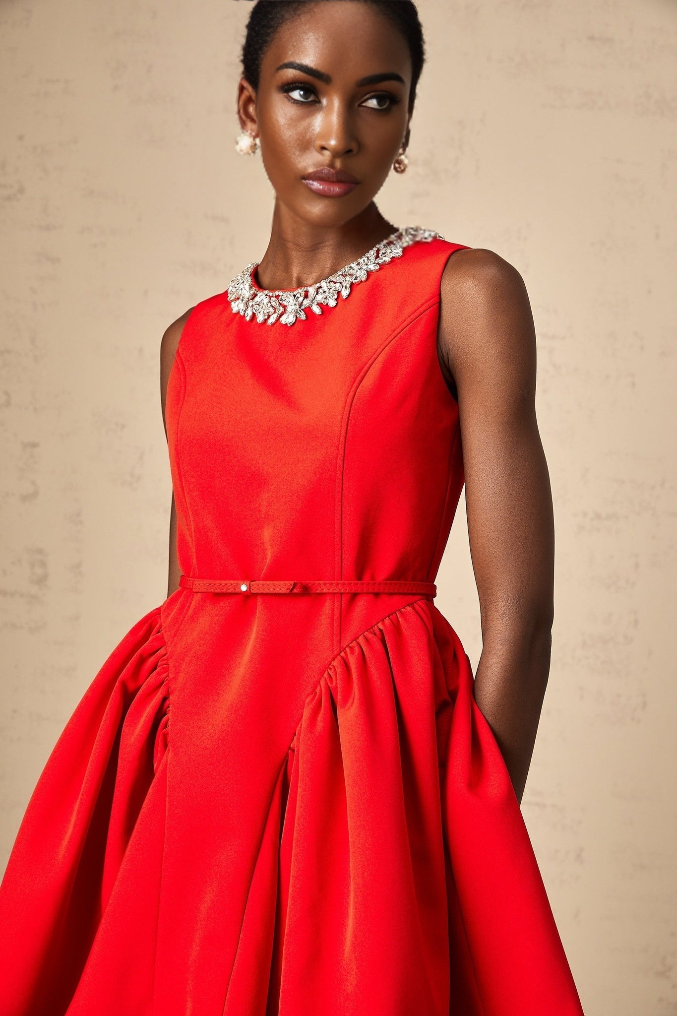 A red mini dress with pleated details and embellishments named Leonie