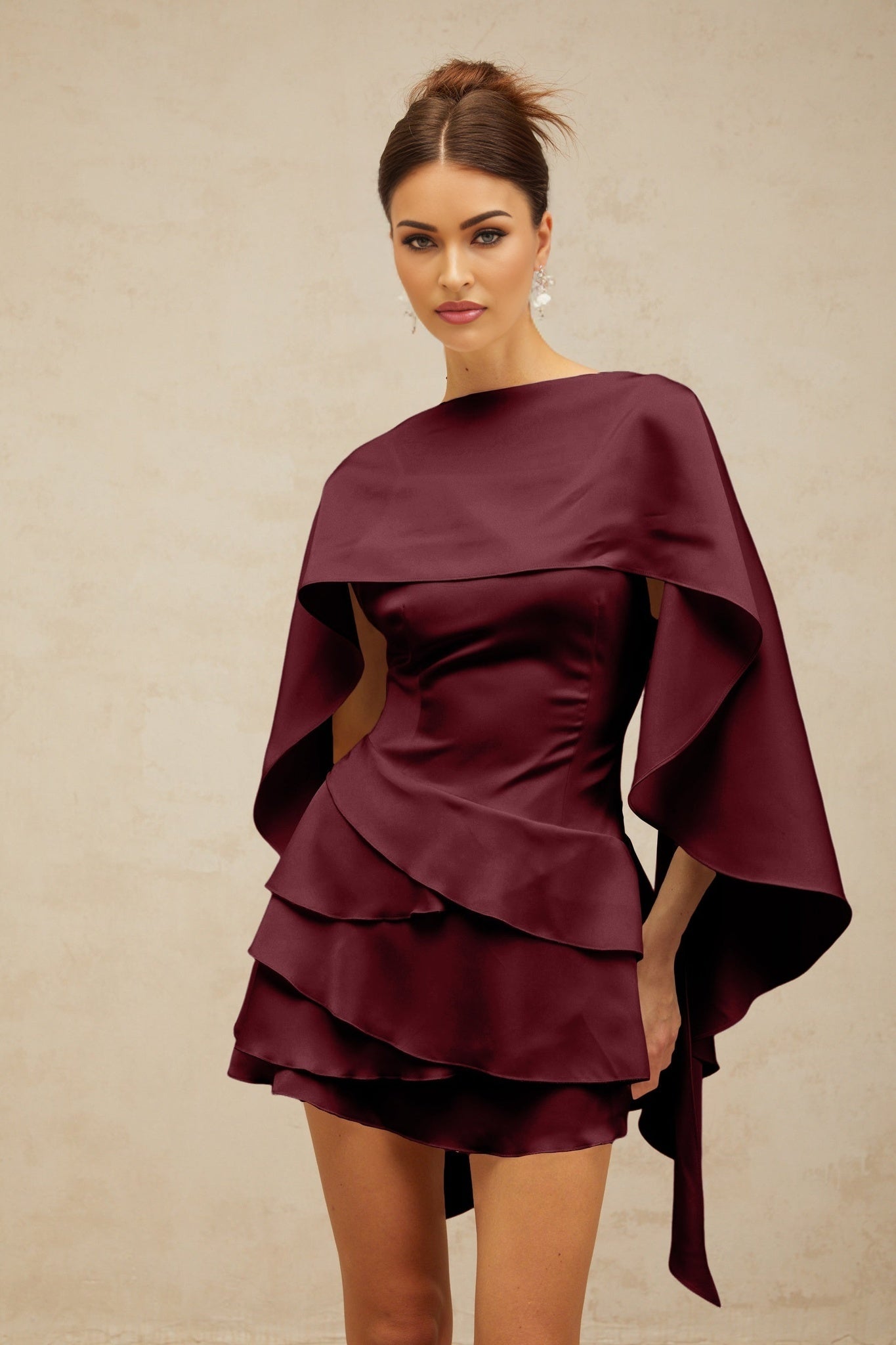 A red satin mini dress with ruffled details and a shawl panel featuring a short hemline and flowing fabric