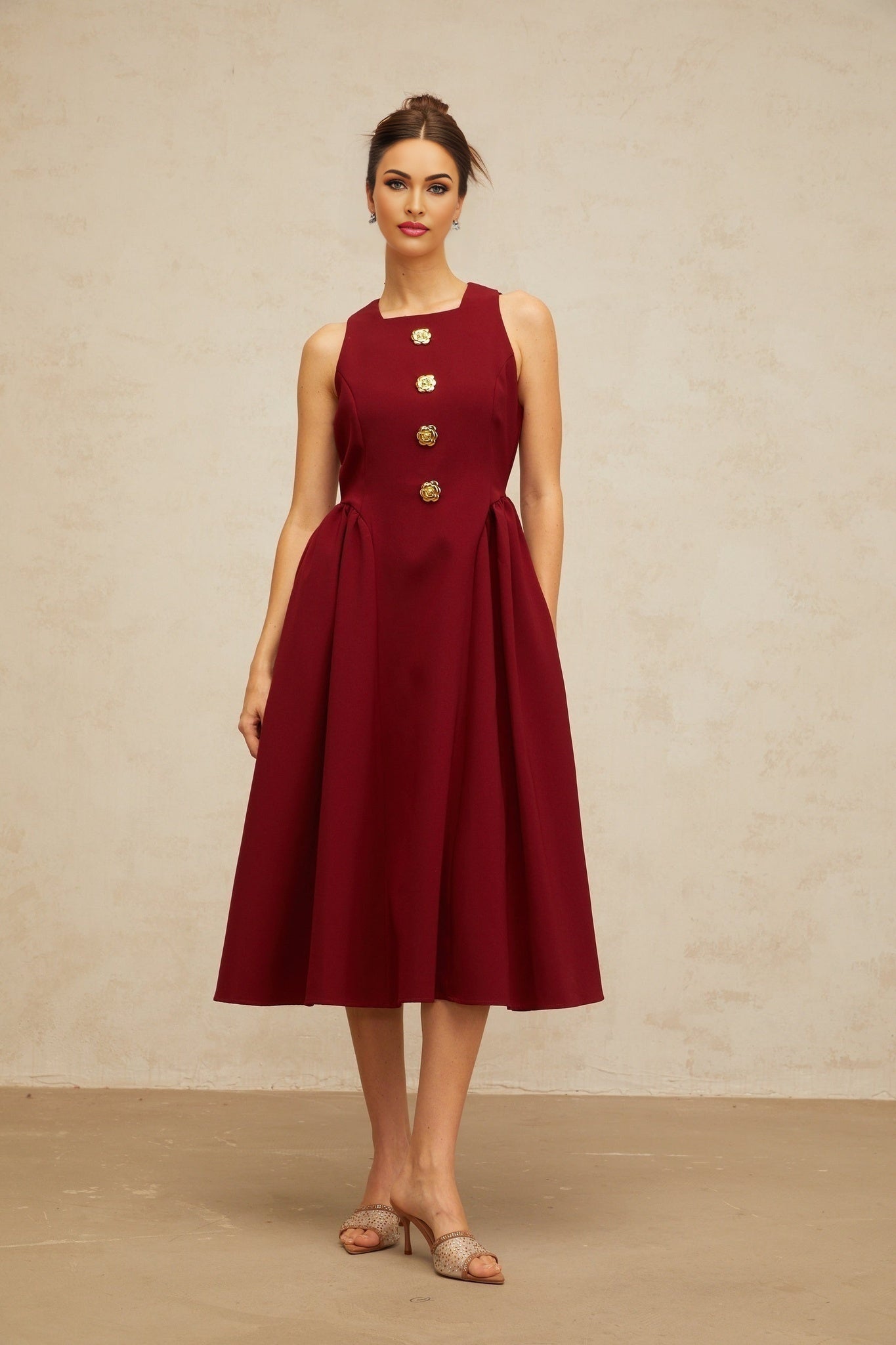 A red sleeveless midi dress with a floral pattern featuring a pleated skirt and tank top style bodice