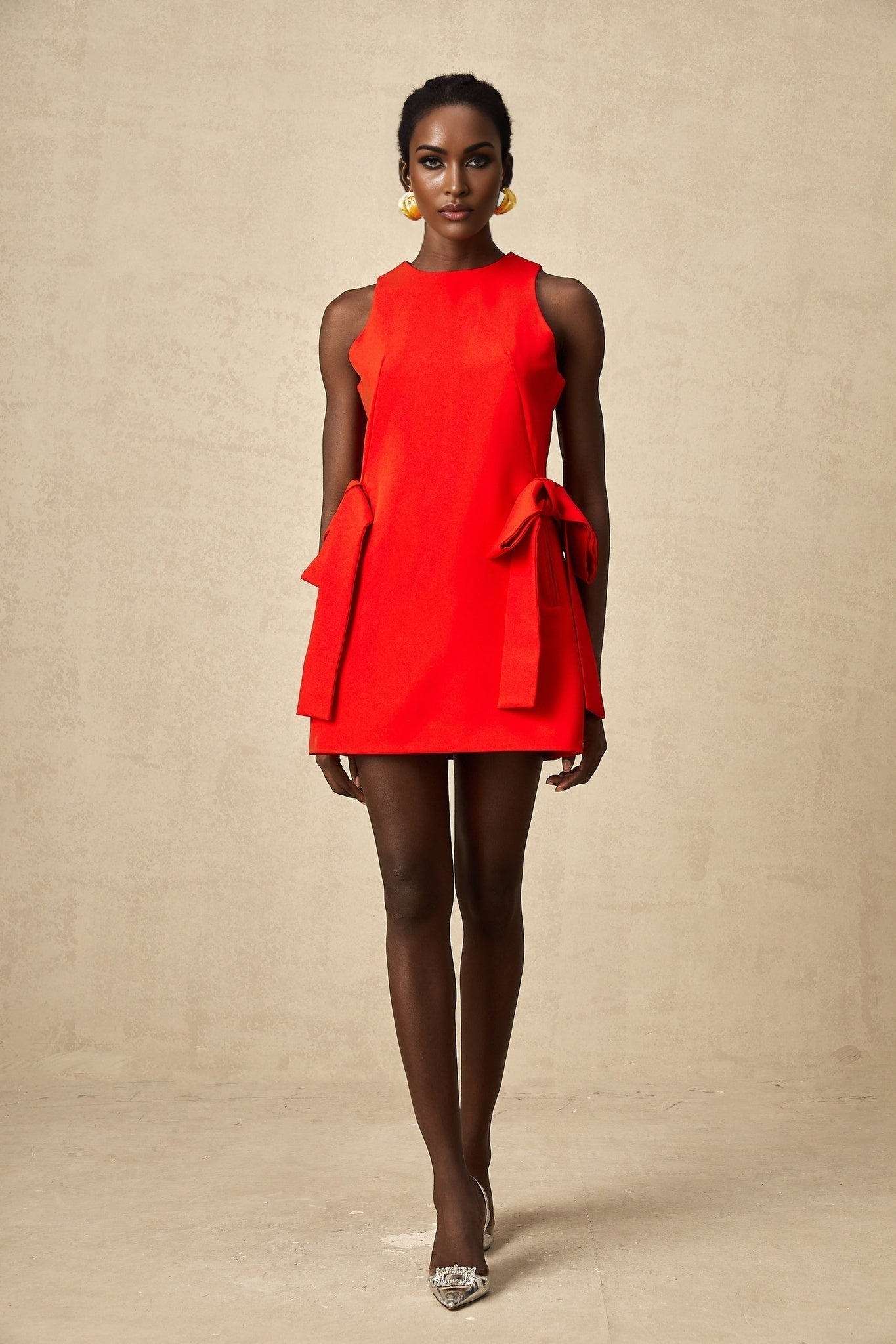 A red sleeveless mini dress with a bow detail named Ronnie