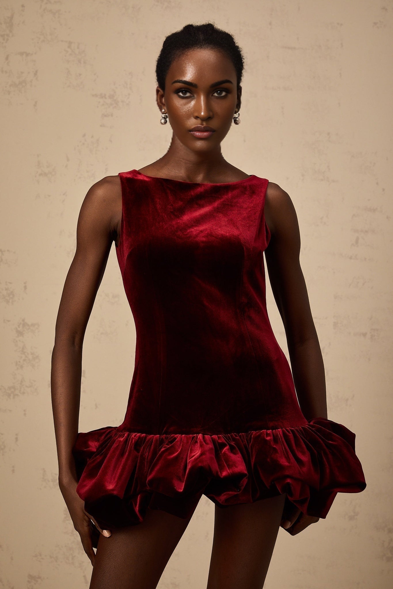 A red velvet mini dress with a peplum hem featuring a fitted bodice and short sleeves named Marion