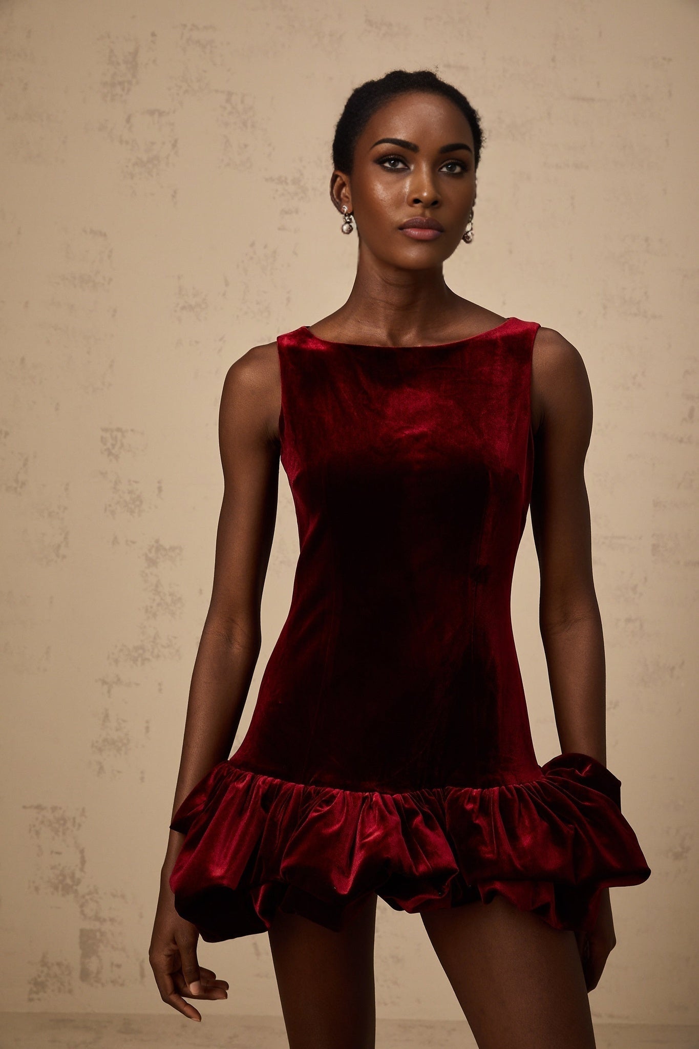 A red velvet mini dress with a peplum hem named Marion featuring a fitted silhouette and short length