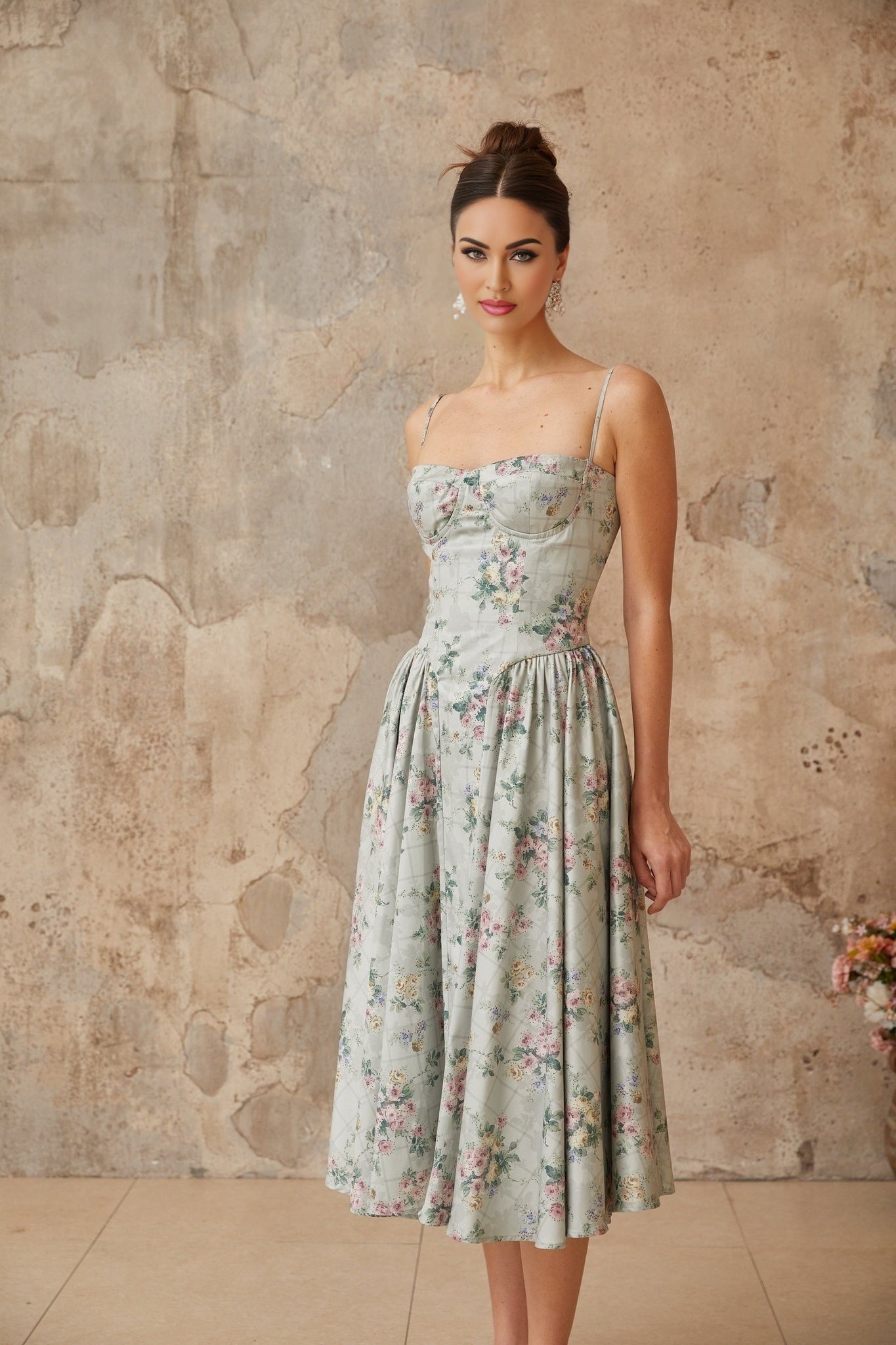A sage green midi dress with a floral print pattern and shirred detailing named Prunelle