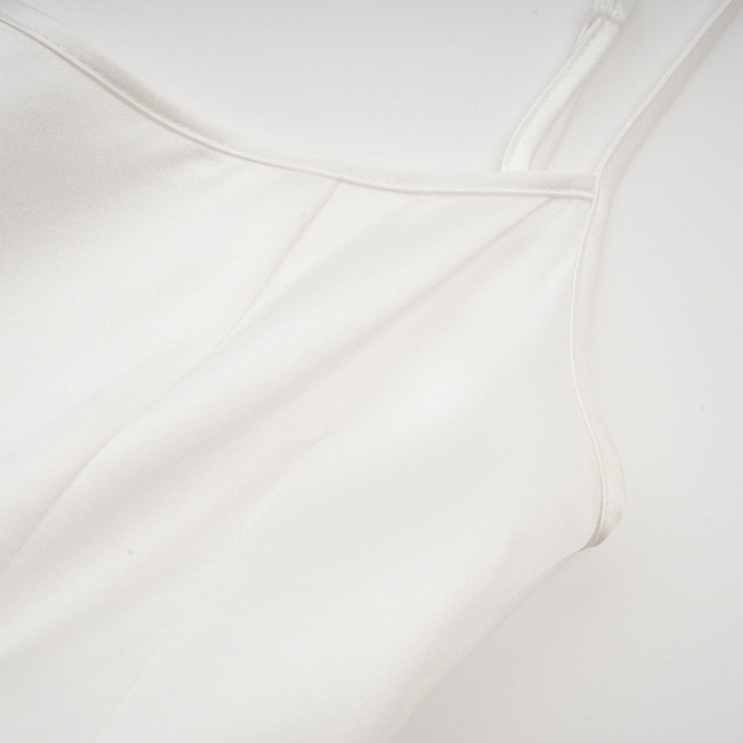 Sleeveless white satin dress with square neck spaghetti straps and asymmetric hem Rear zip fastening Thigh length Composed of 56% polyester 44% acetate