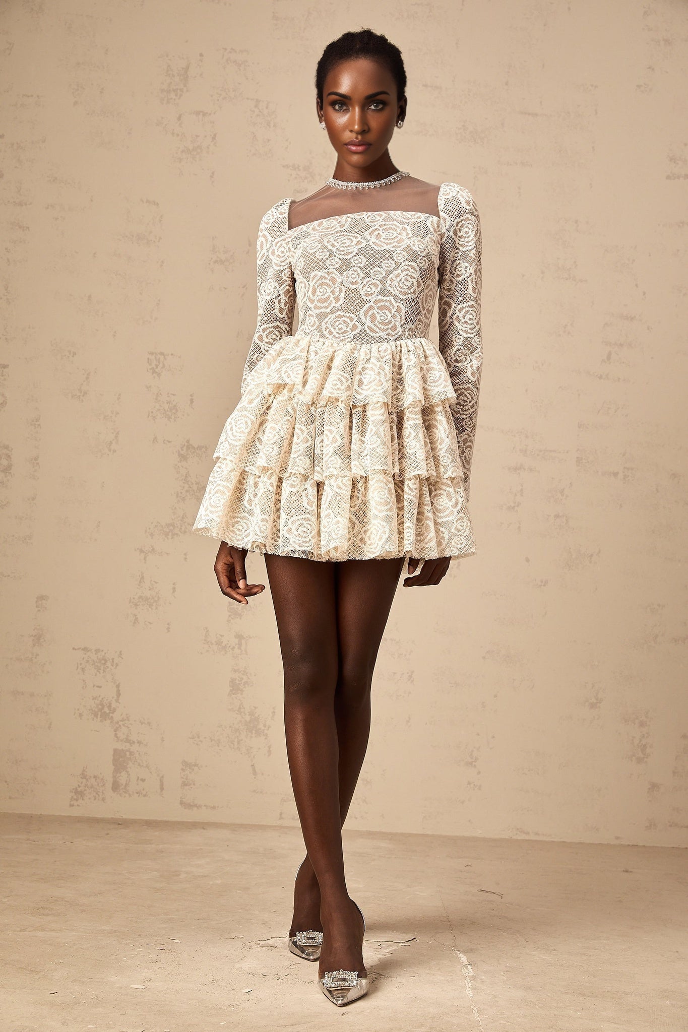 A short beige mini dress with delicate floral embroidery featuring a fitted waist and short sleeves