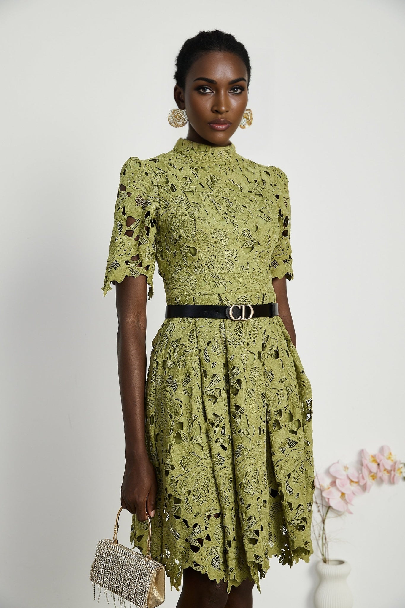 A short beige mini dress with embroidery details and cut out sections on the sides modeled on a female figure