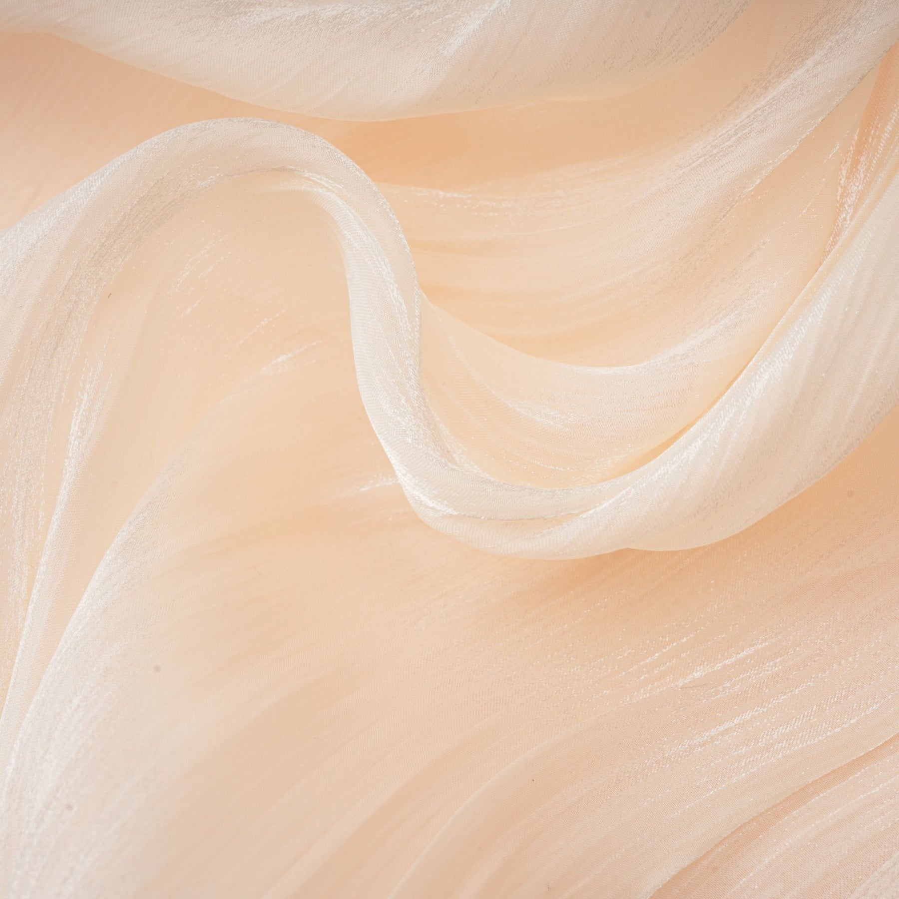 A short beige mini dress with full pleats and ruffles throughout featuring a flowy silhouette and feminine details