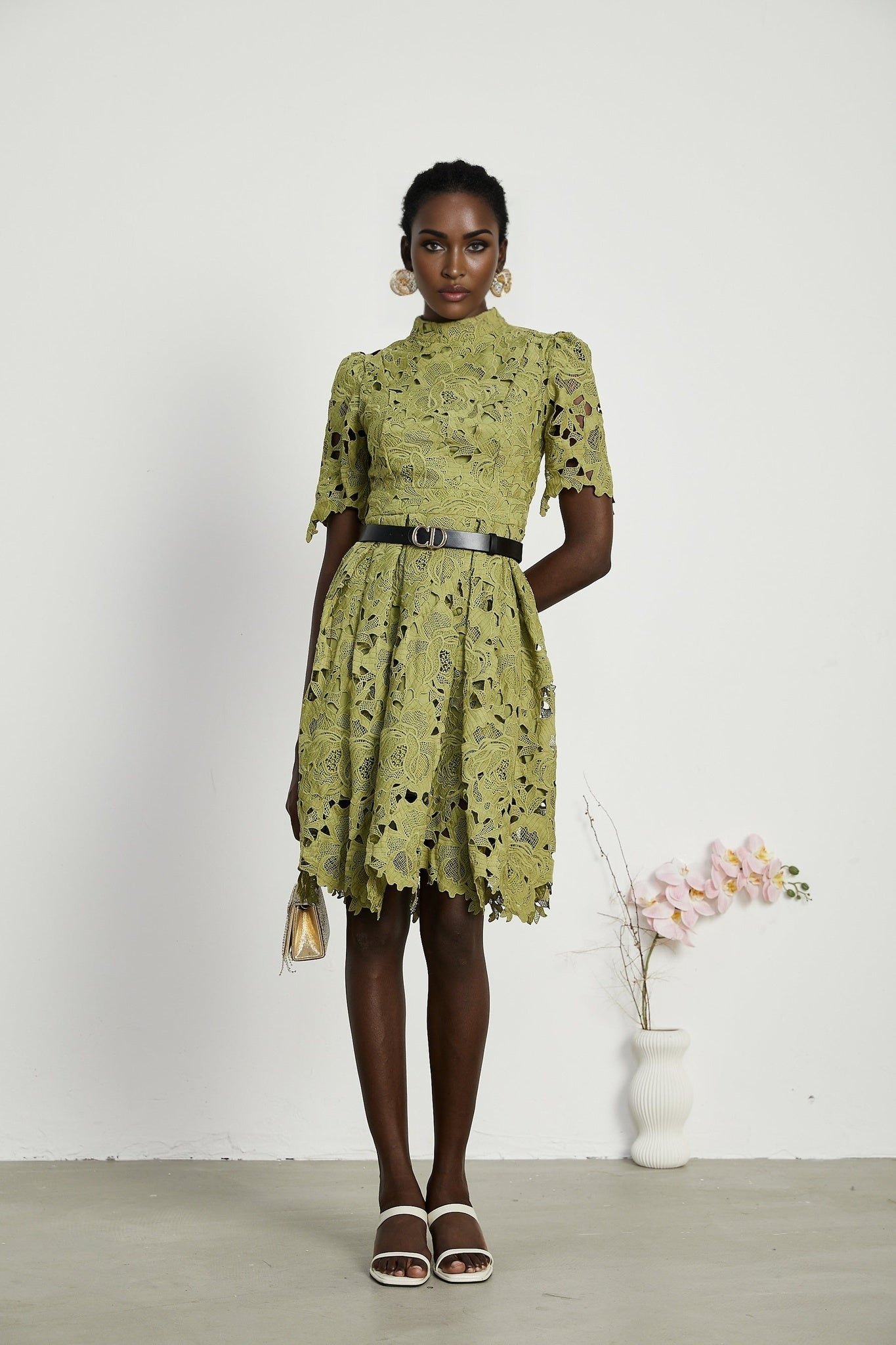 A short beige minidress with embroidery details and cutout sections worn by a model
