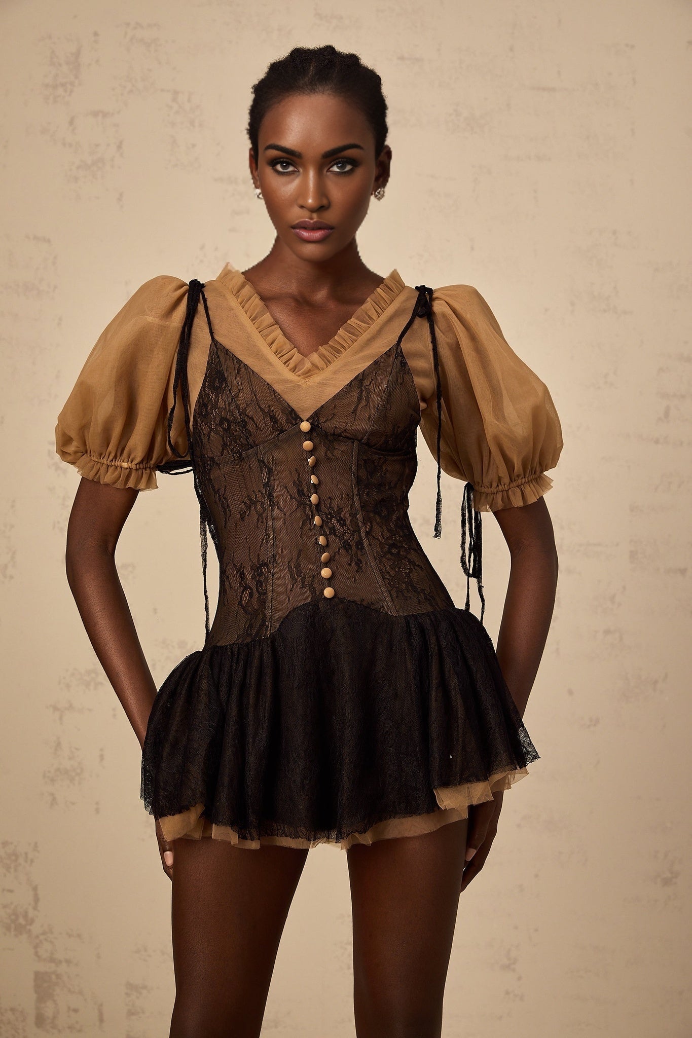A short black mini dress with lace panelling details featuring a fitted silhouette and delicate floral lace accents