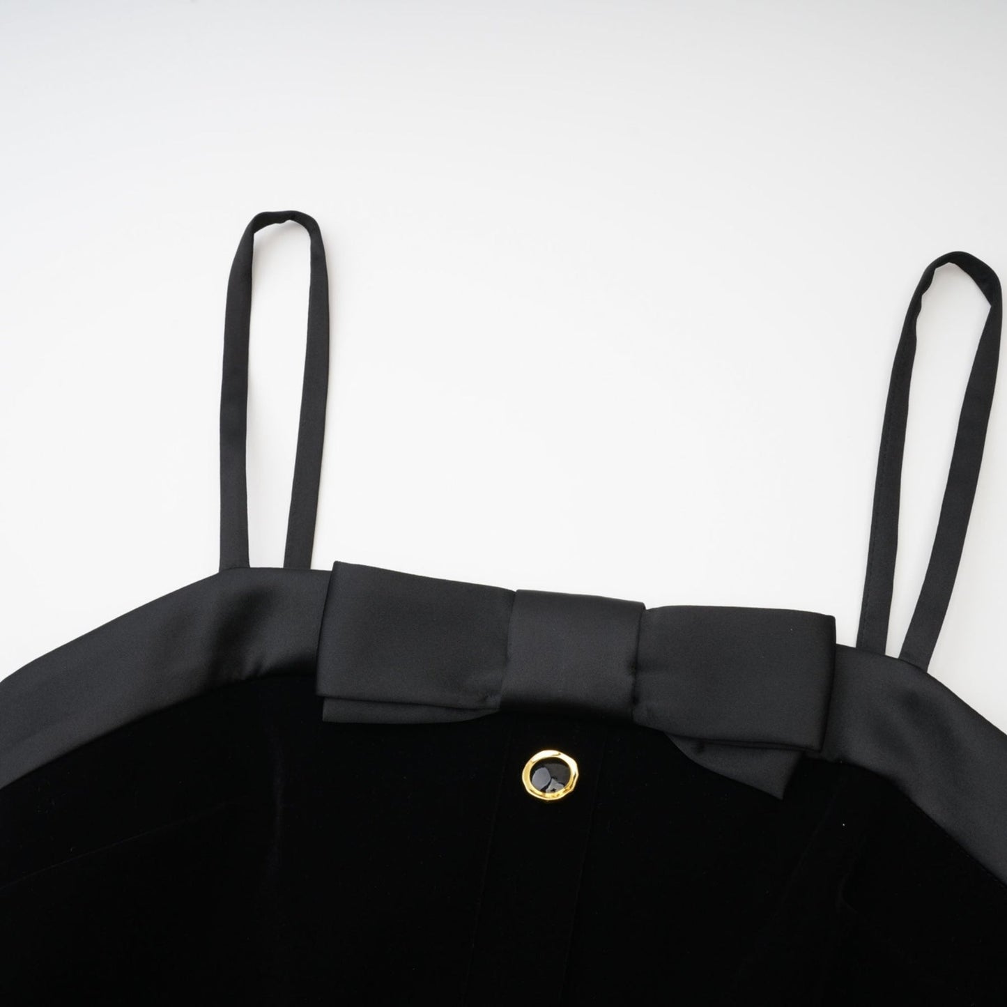 Sleeveless black dress with spaghetti straps bow detail decorative button and side zip Thi%h length made of 65% Viscose 35% Cupro