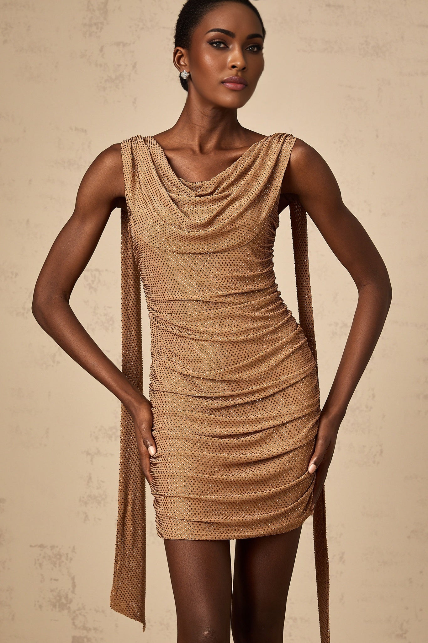 A short brown dress with rhinestone embellishments worn by a model named Jacqueline featuring a mini length and likely a fitted silhouette