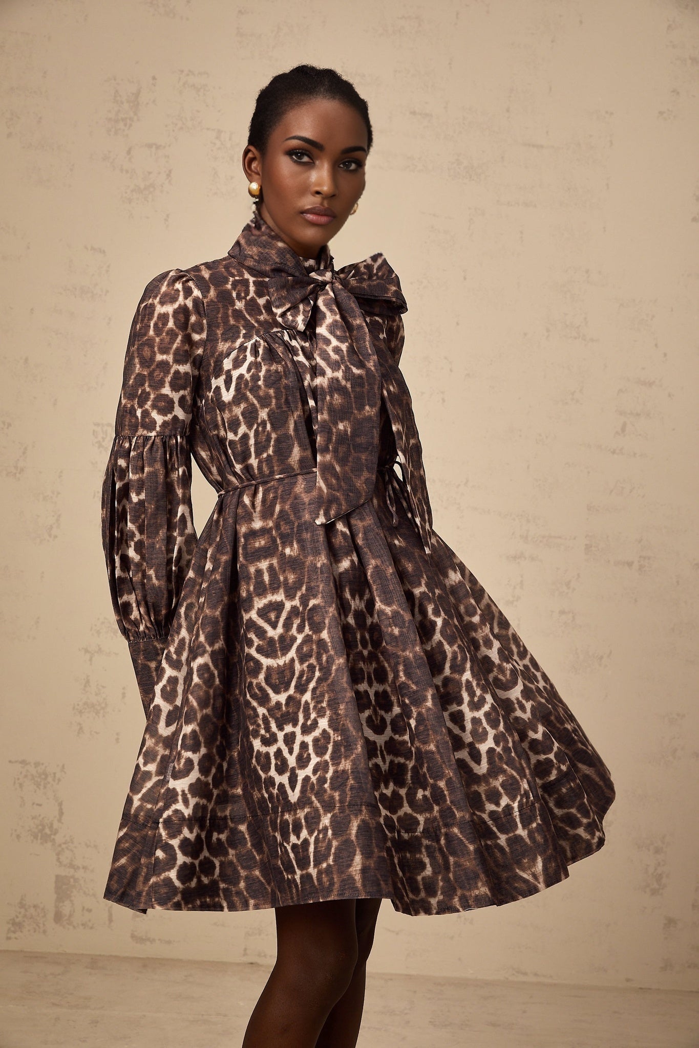 A short brown mini dress with leopard print featuring a large bowknot detail in xylene color