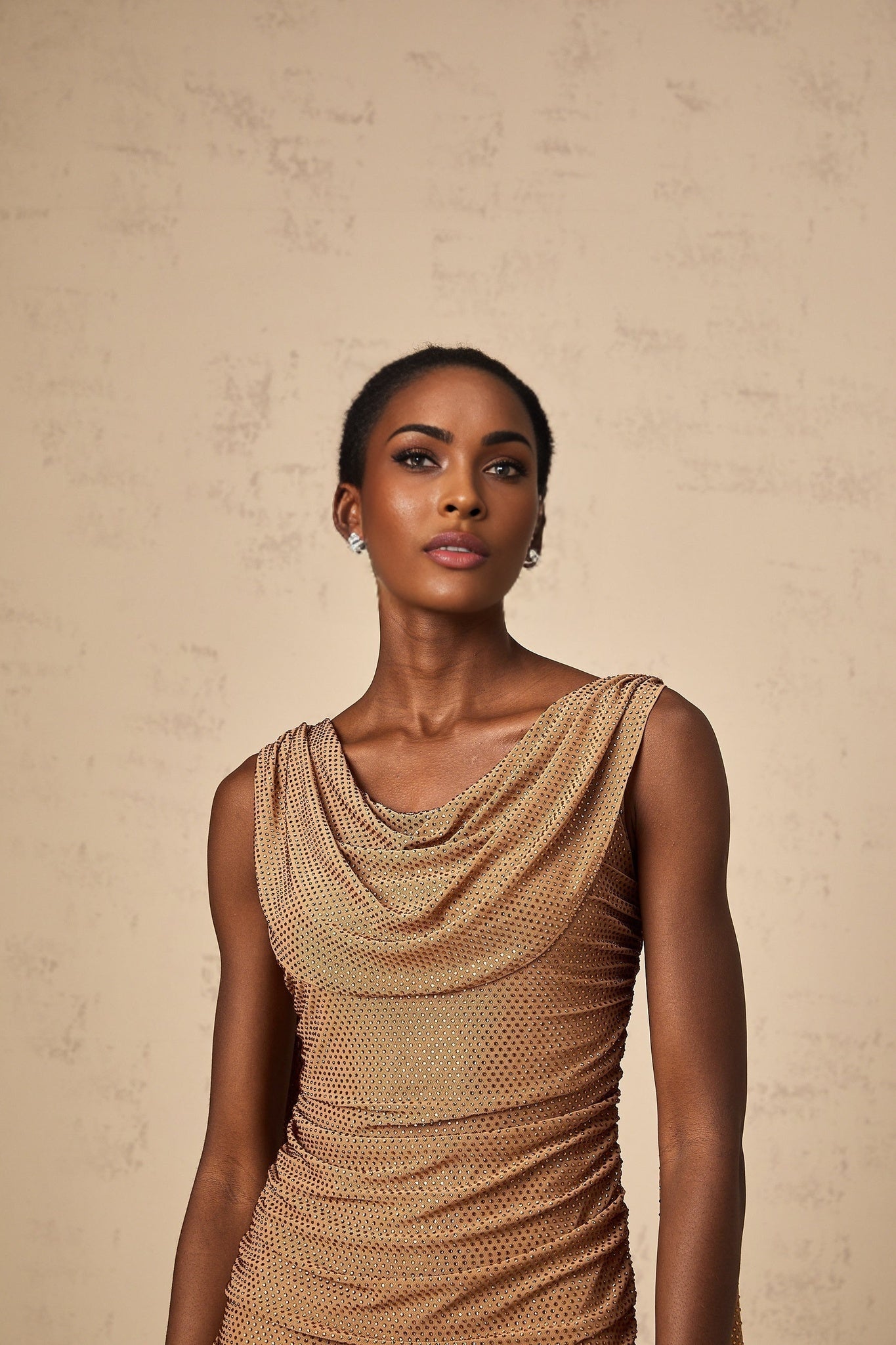 A short brown mini dress with rhinestone embellishments featuring a fitted silhouette and shimmering details