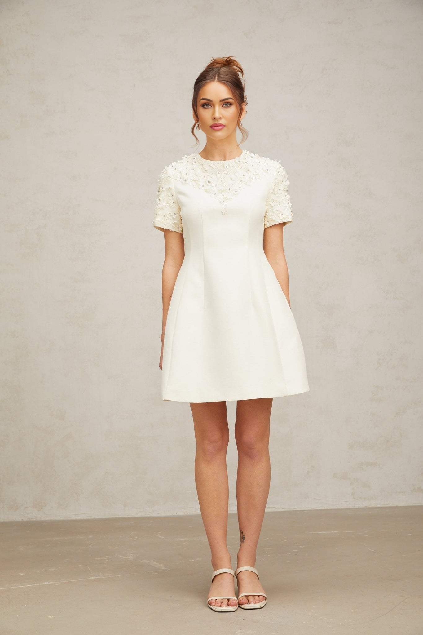 A short dress with a floral applique design featuring Adrienne style in a mini length
