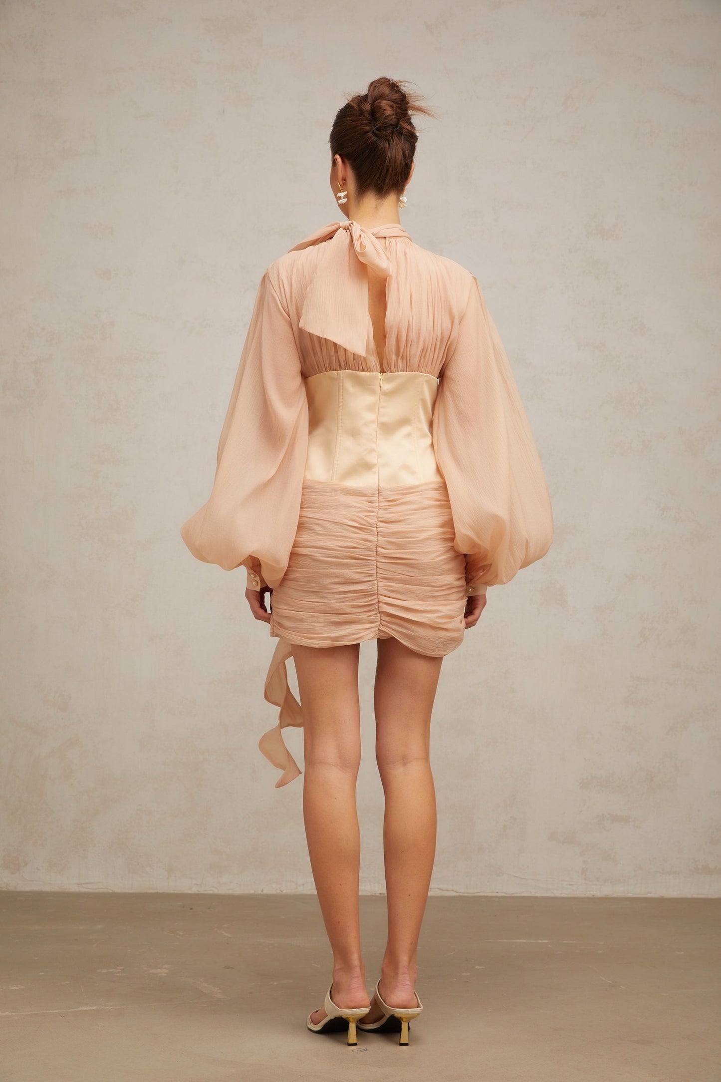 A short floral dress with cinched waist and floral appliques on a paneled design