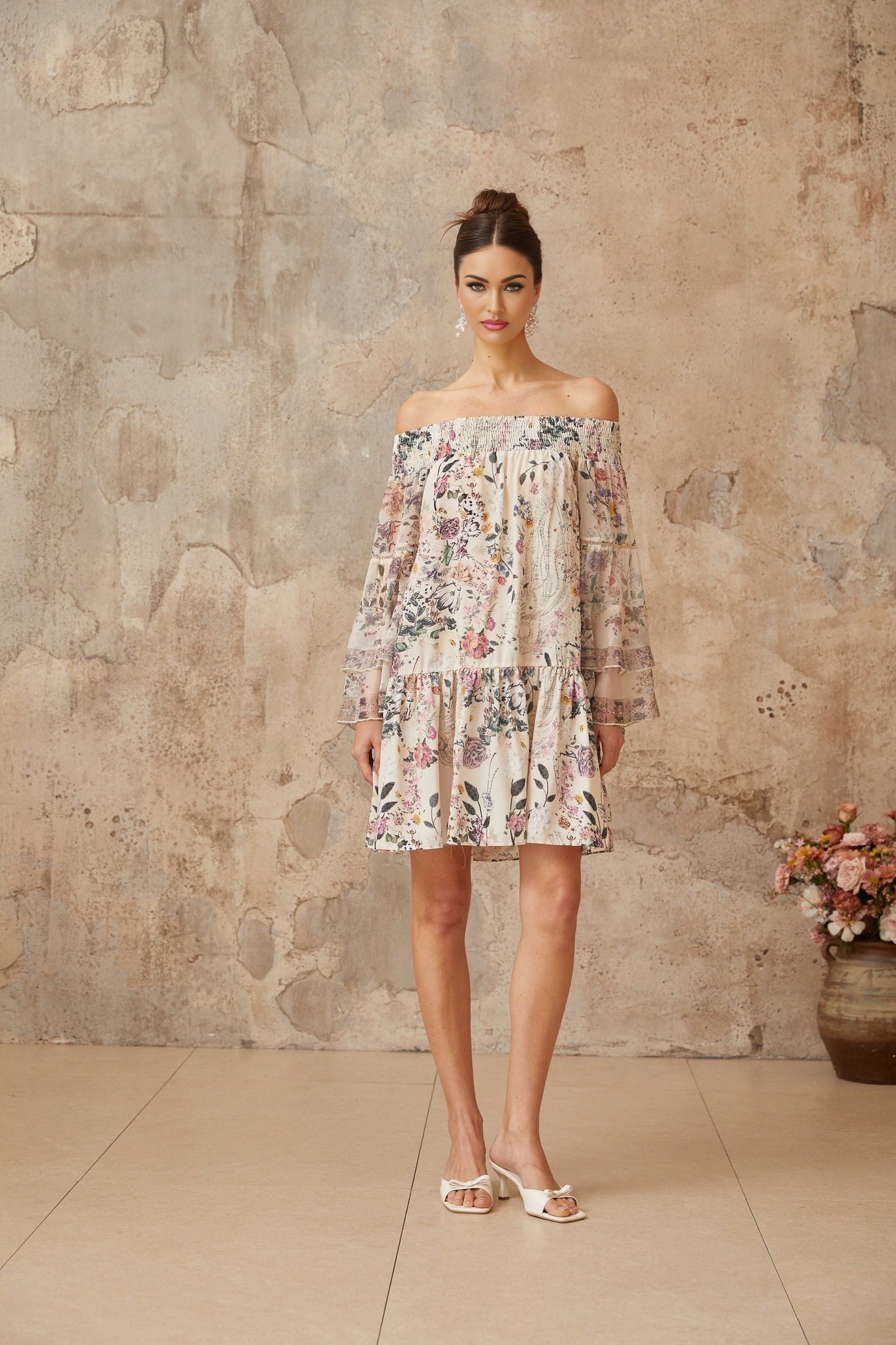 A short floral print mini dress with smocked detailing named Yasmine worn by a model against a plain background
