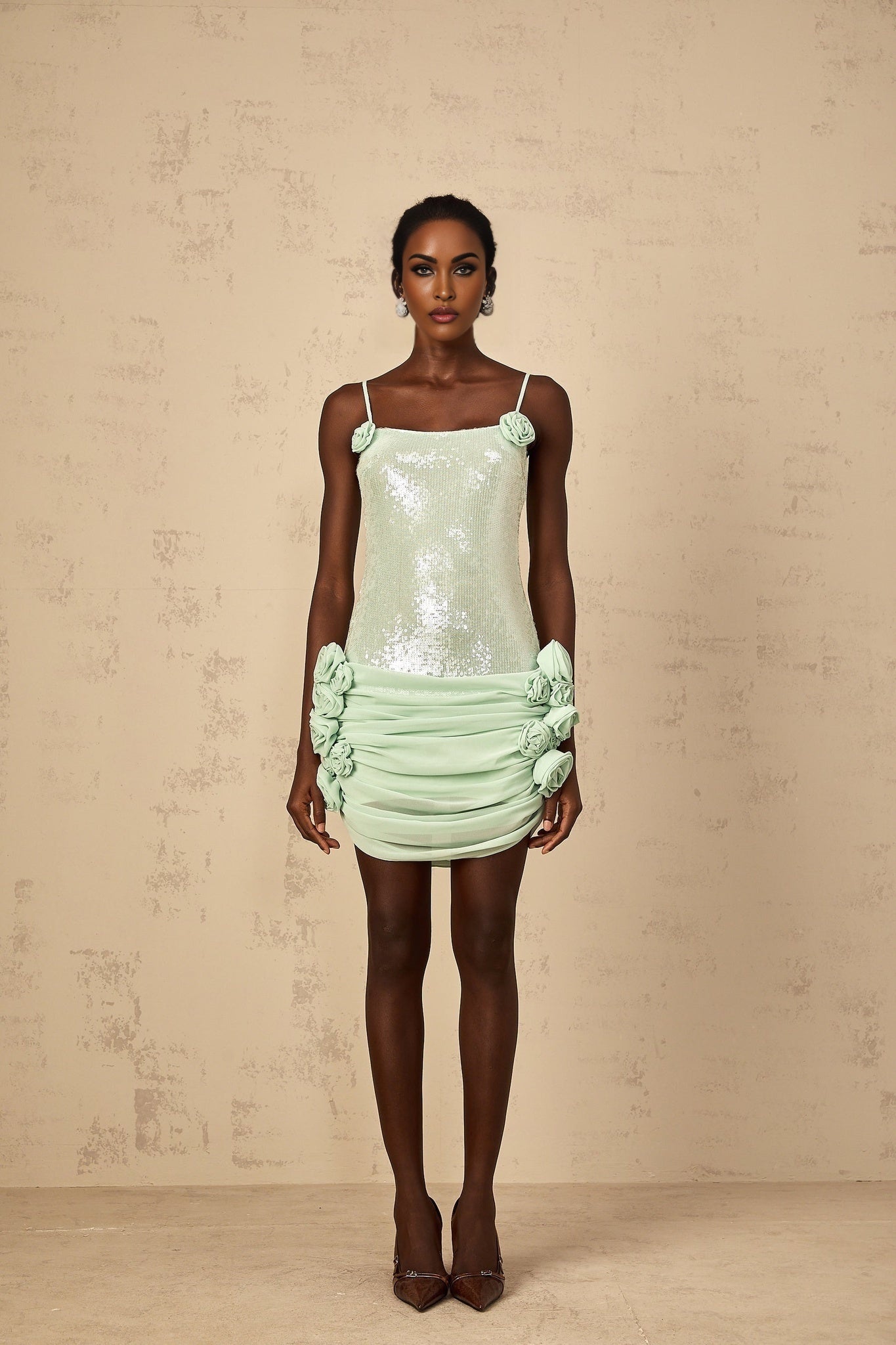 A short green mini dress with floral pattern and sequin embellishments