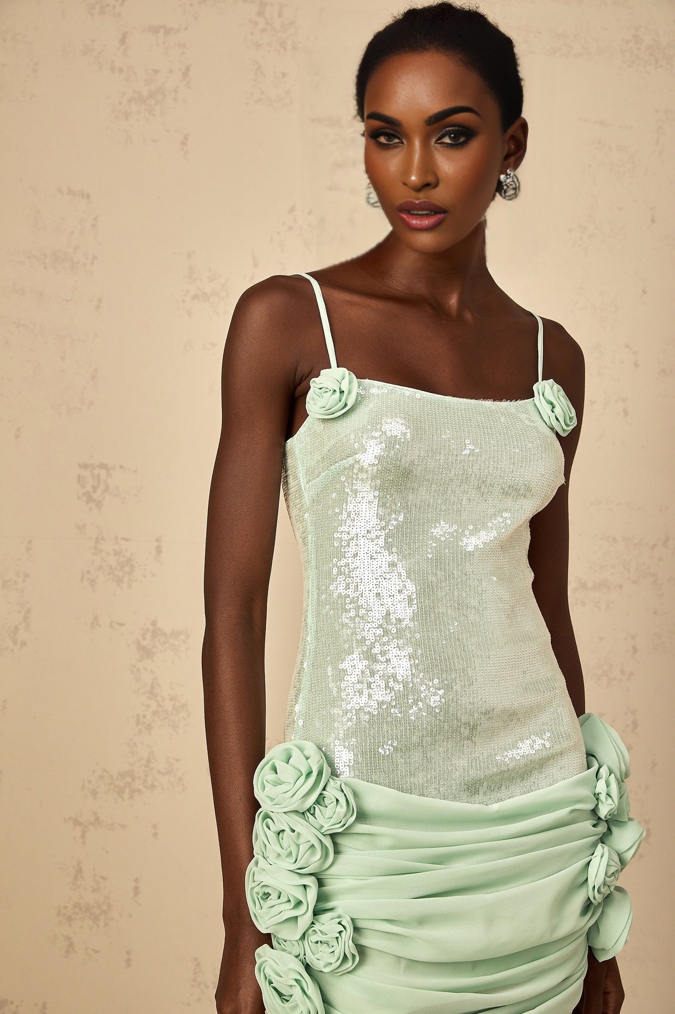 A short green mini dress with floral pattern and sequin embellishments