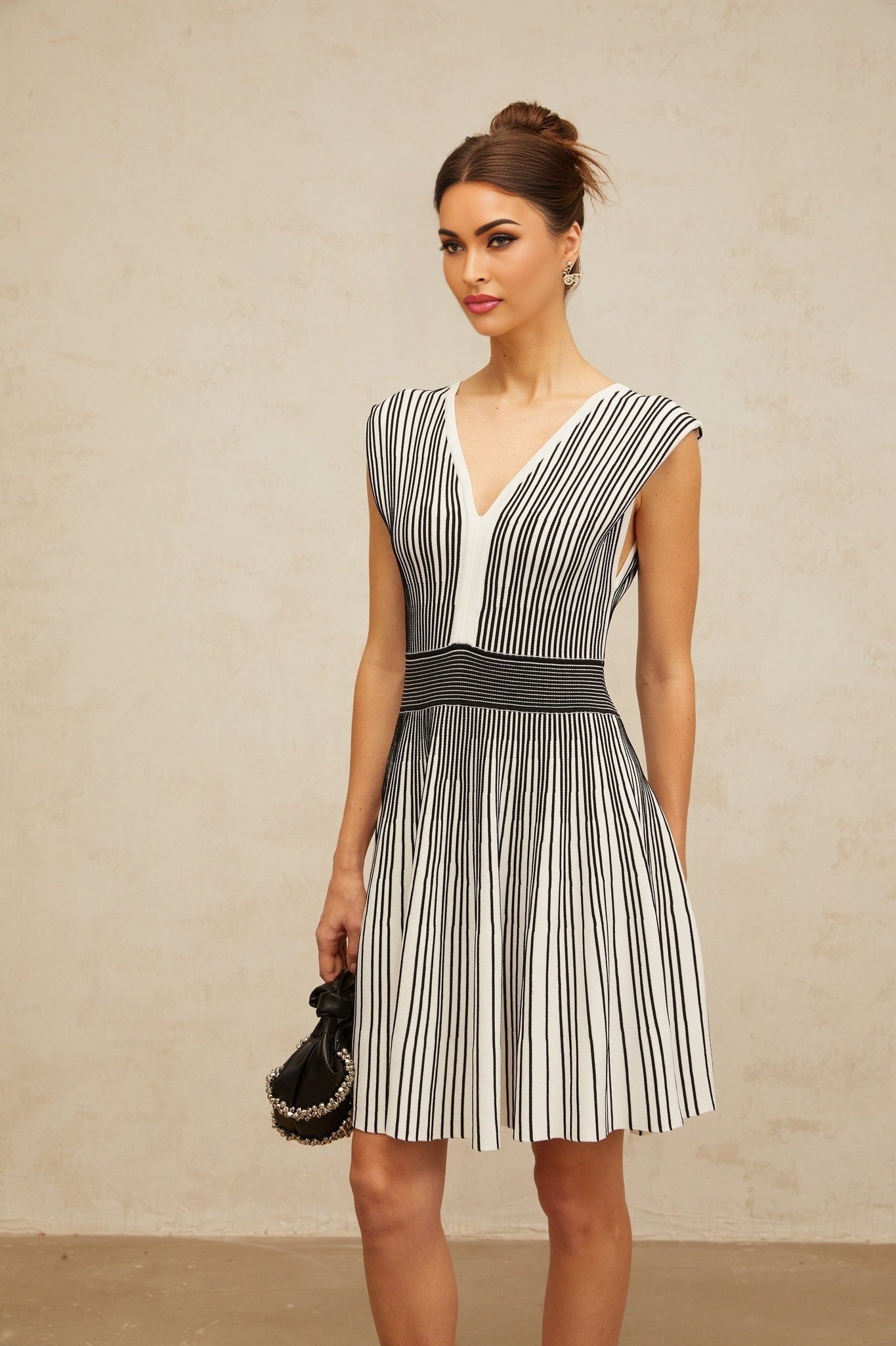 A short knit mini dress with vertical stripes in contrasting colors featuring a design by Joelle