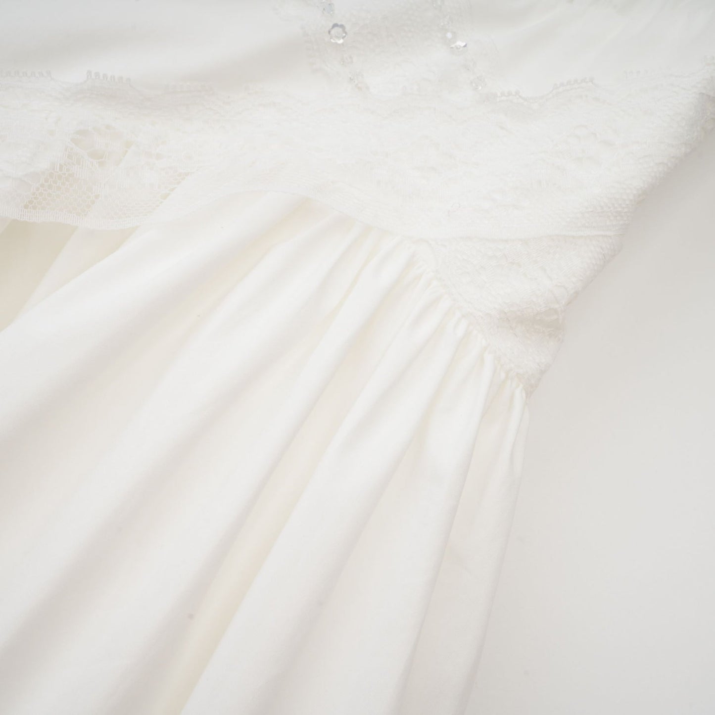White Uneck sleeveless dress with ruffled crystal embellishments and pleat detailing Rear zip fastening and mini length Made of 100% Cotton