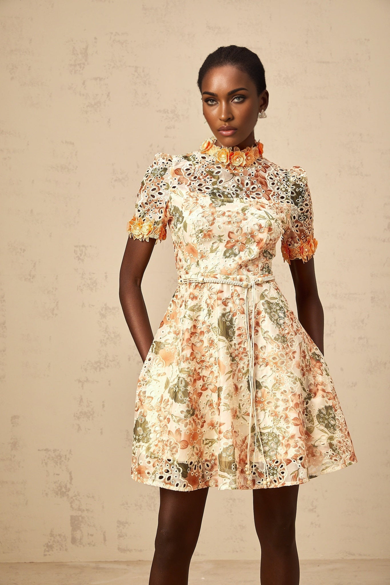 A short orange mini dress with embroidered flowers and embellishments adorning the fabric