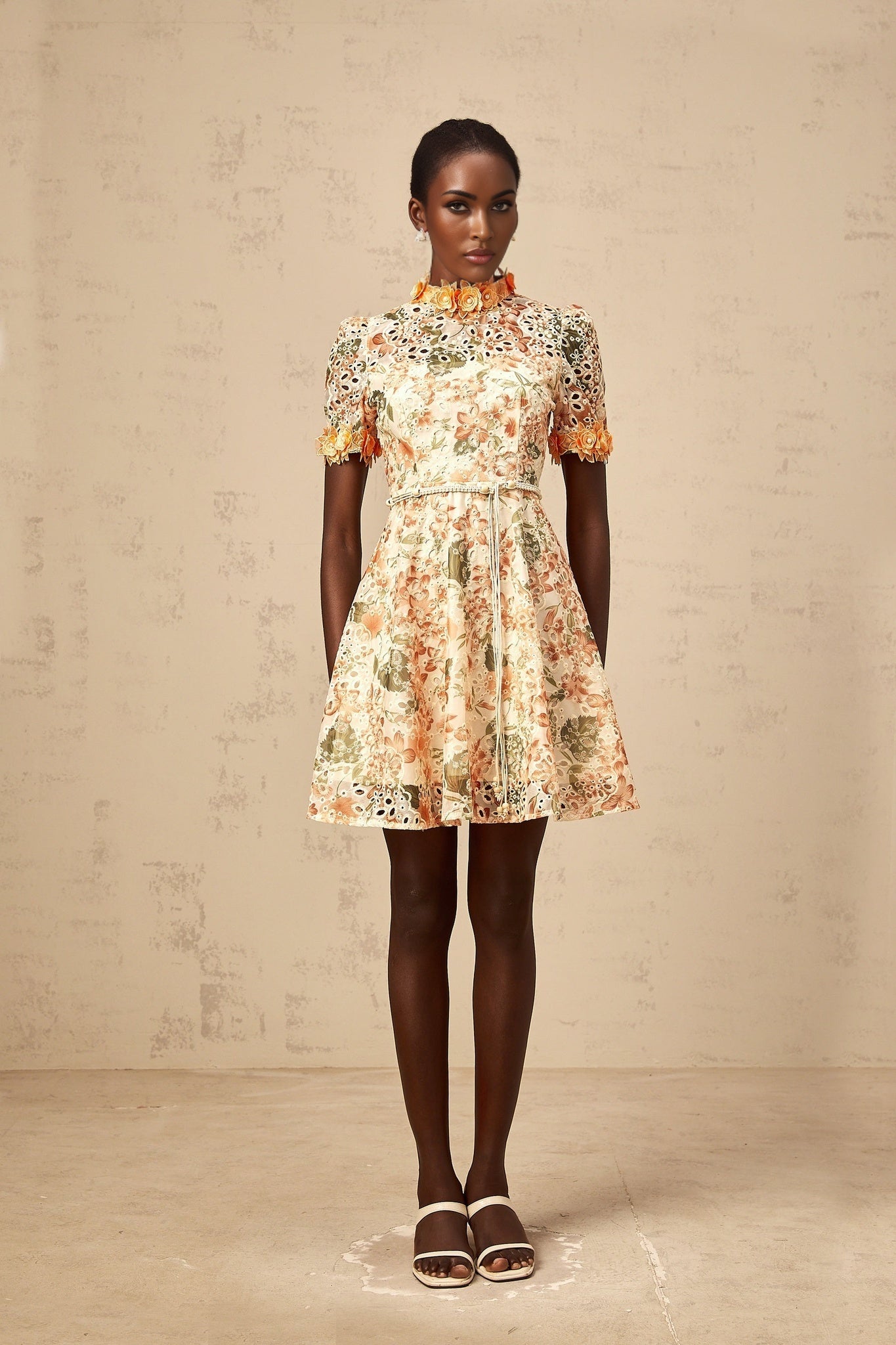 A short orange mini dress with floral embroidery and embellishments featuring a fitted silhouette and delicate flower details
