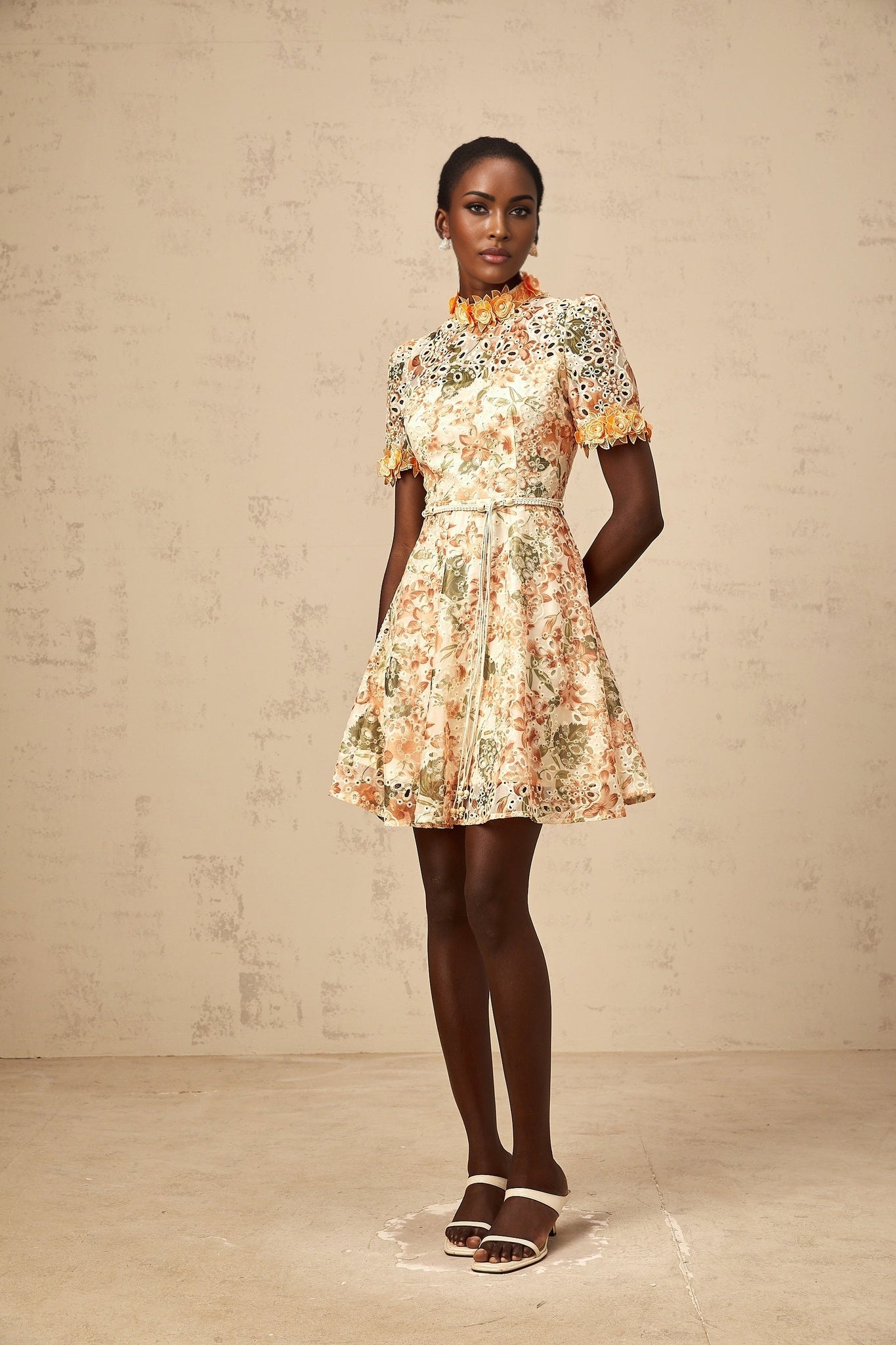 A short orange mini dress with floral embroidery and embellishments featuring a flower pattern