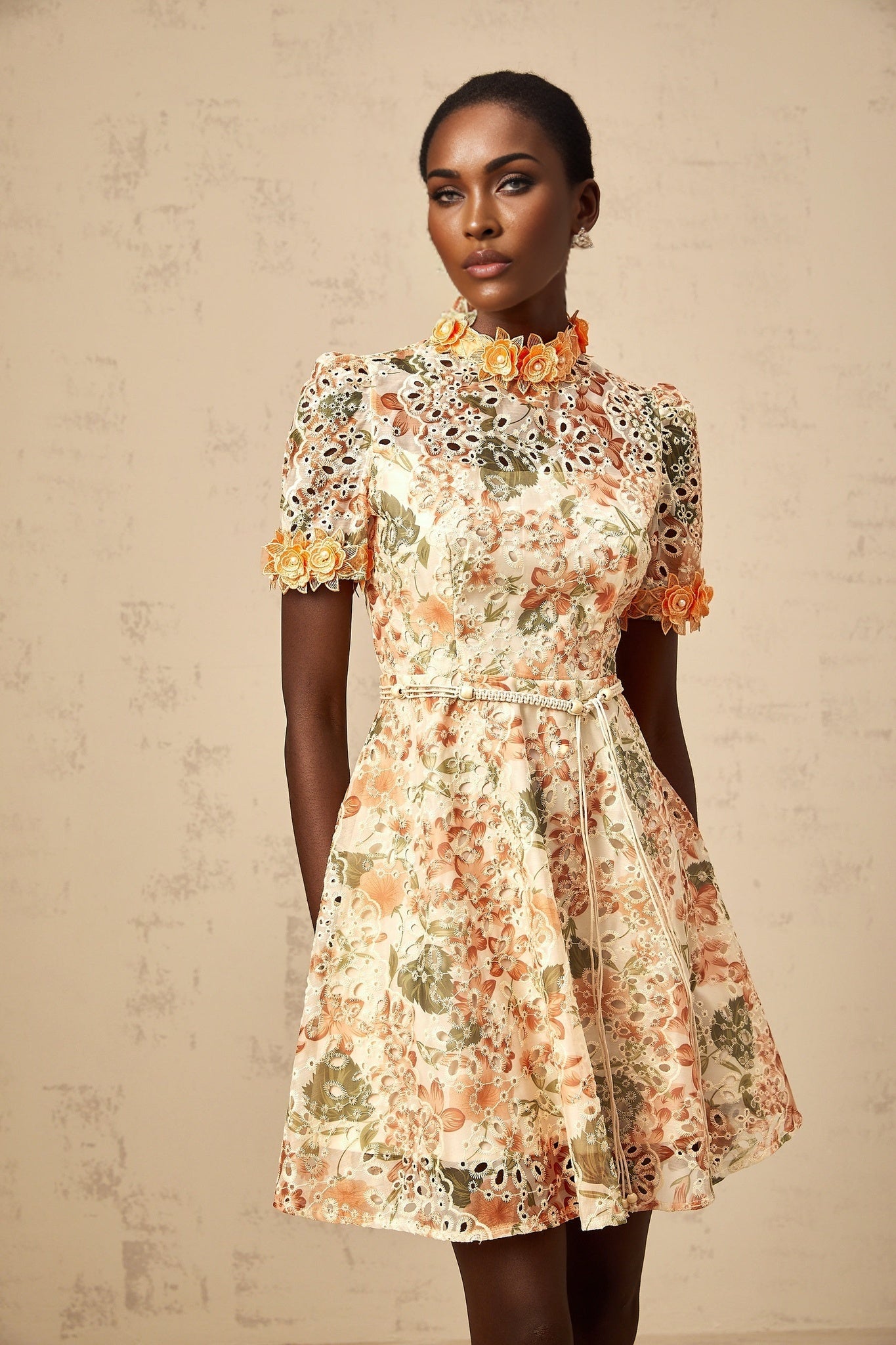 A short orange mini dress with flower embroidery and embellishments on the fabric