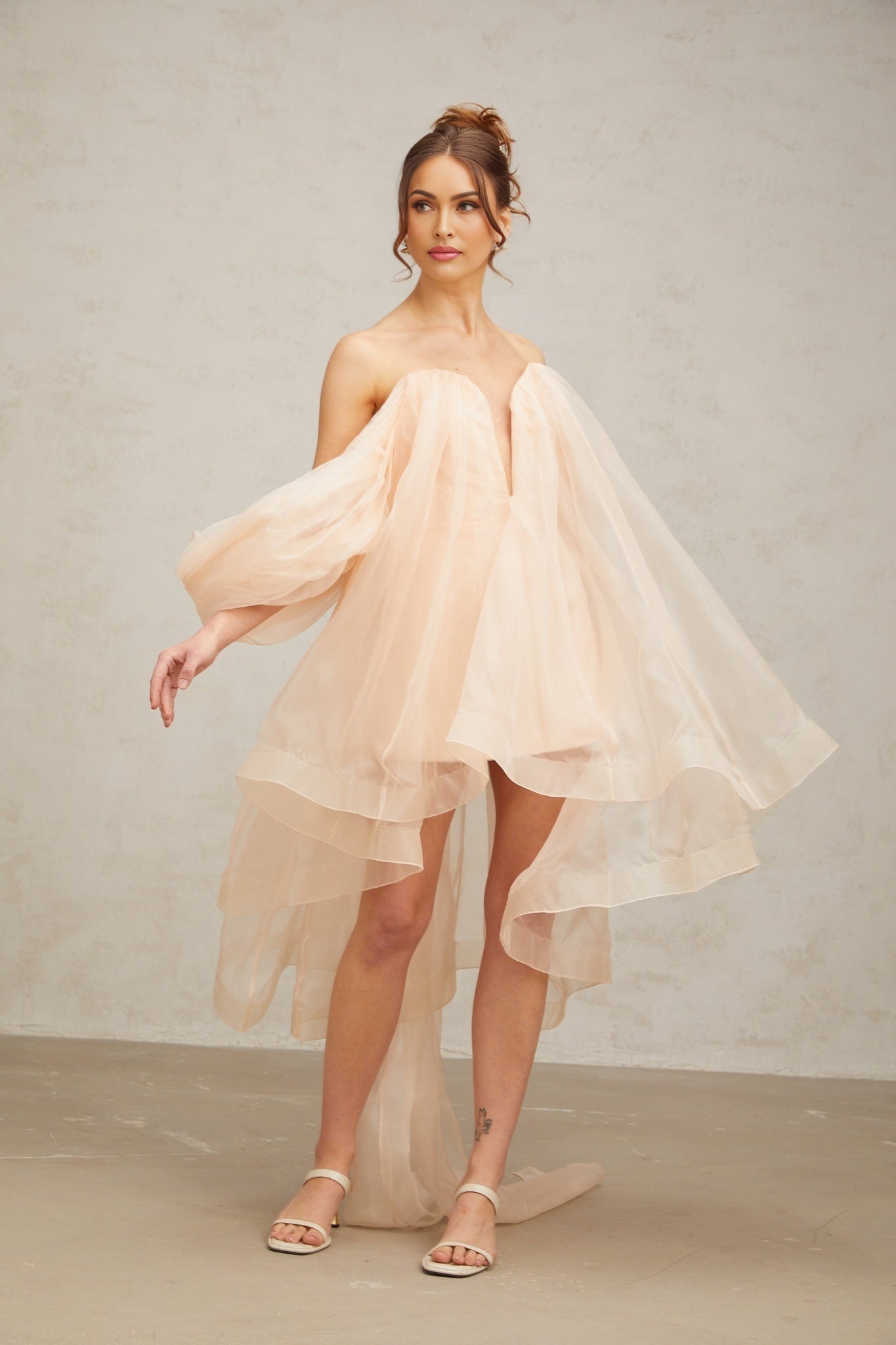 A short pink mini dress with voluminous sleeves and a large bow detail at the neckline
