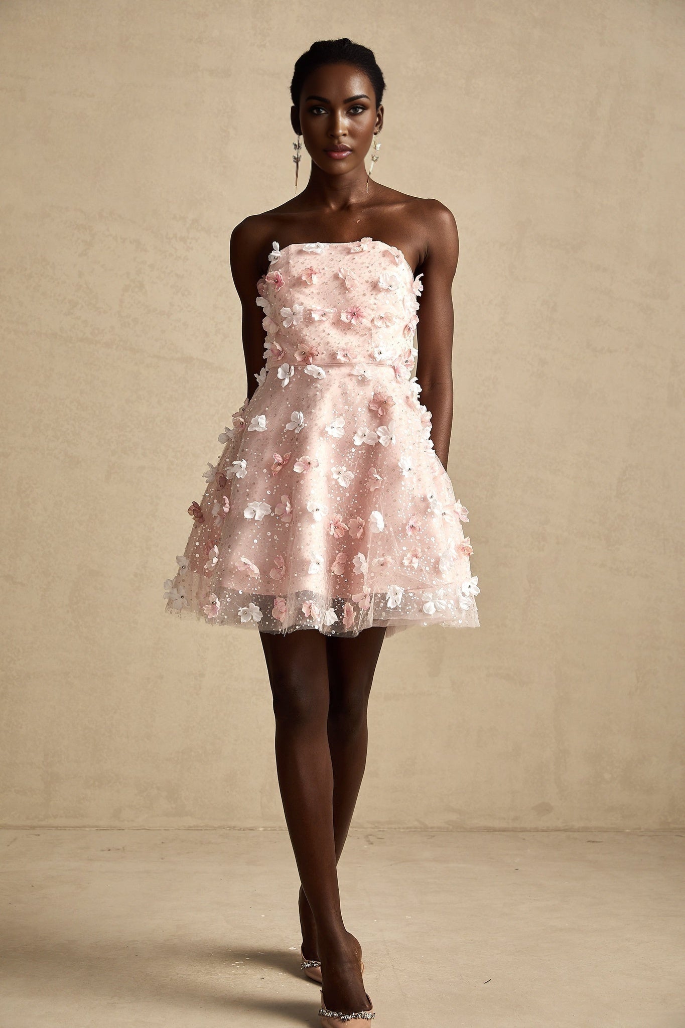 A short puffy mini dress with threedimensional floral petal details covering the fabric creating a textured and voluminous appearance