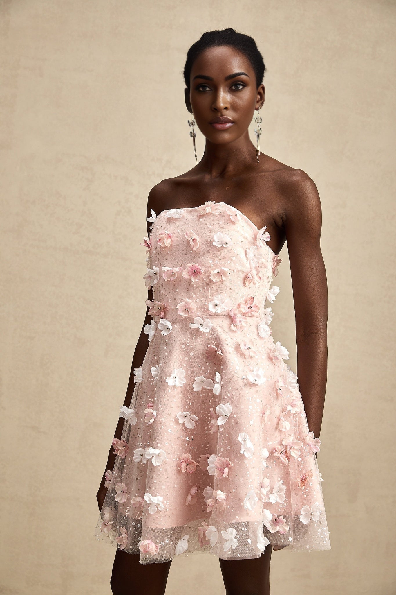 A short puffy mini dress with threedimensional petal details covering the fabric creating a textured floral appearance