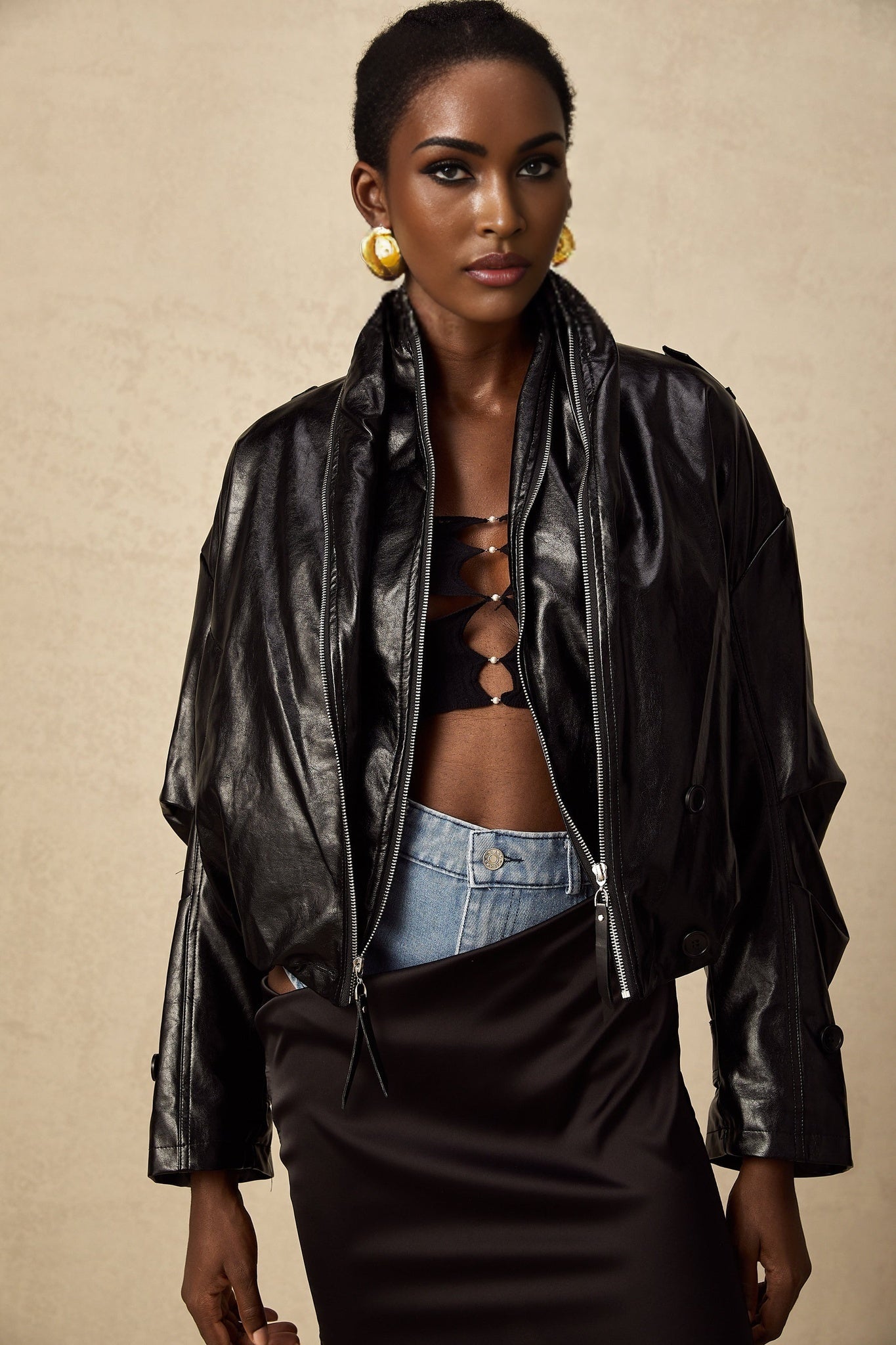 A short quilted leather jacket in dark brown featuring a standup collar zippered front and side pockets