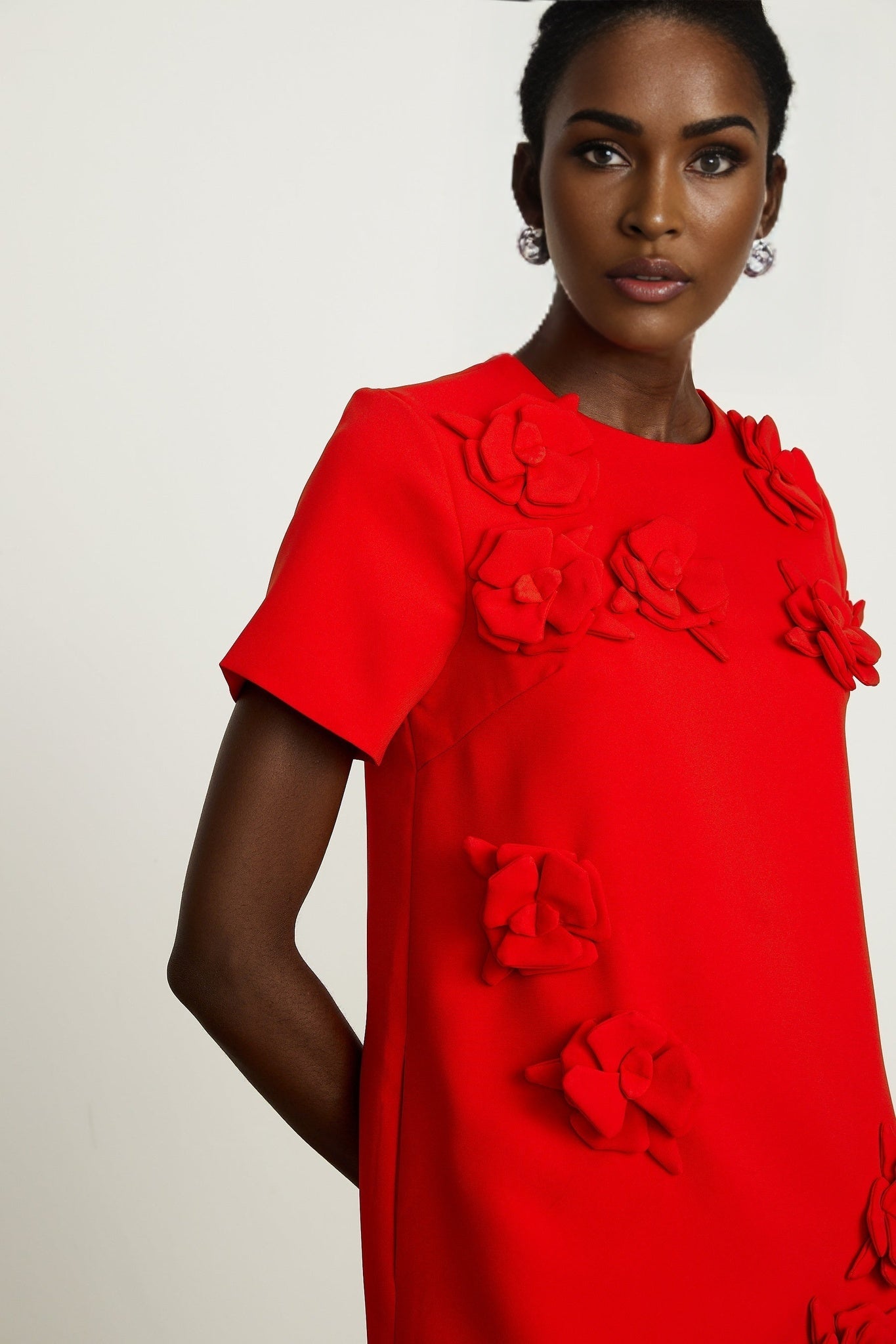 A short red mini dress with floral details and short sleeves featuring a Calista design