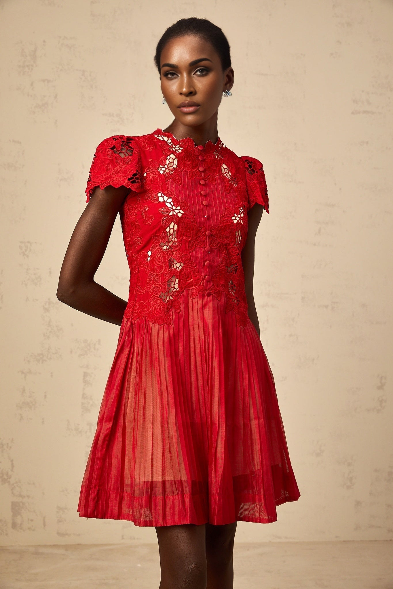 A short red mini dress with pleated skirt and floral embroidery details named Corinne