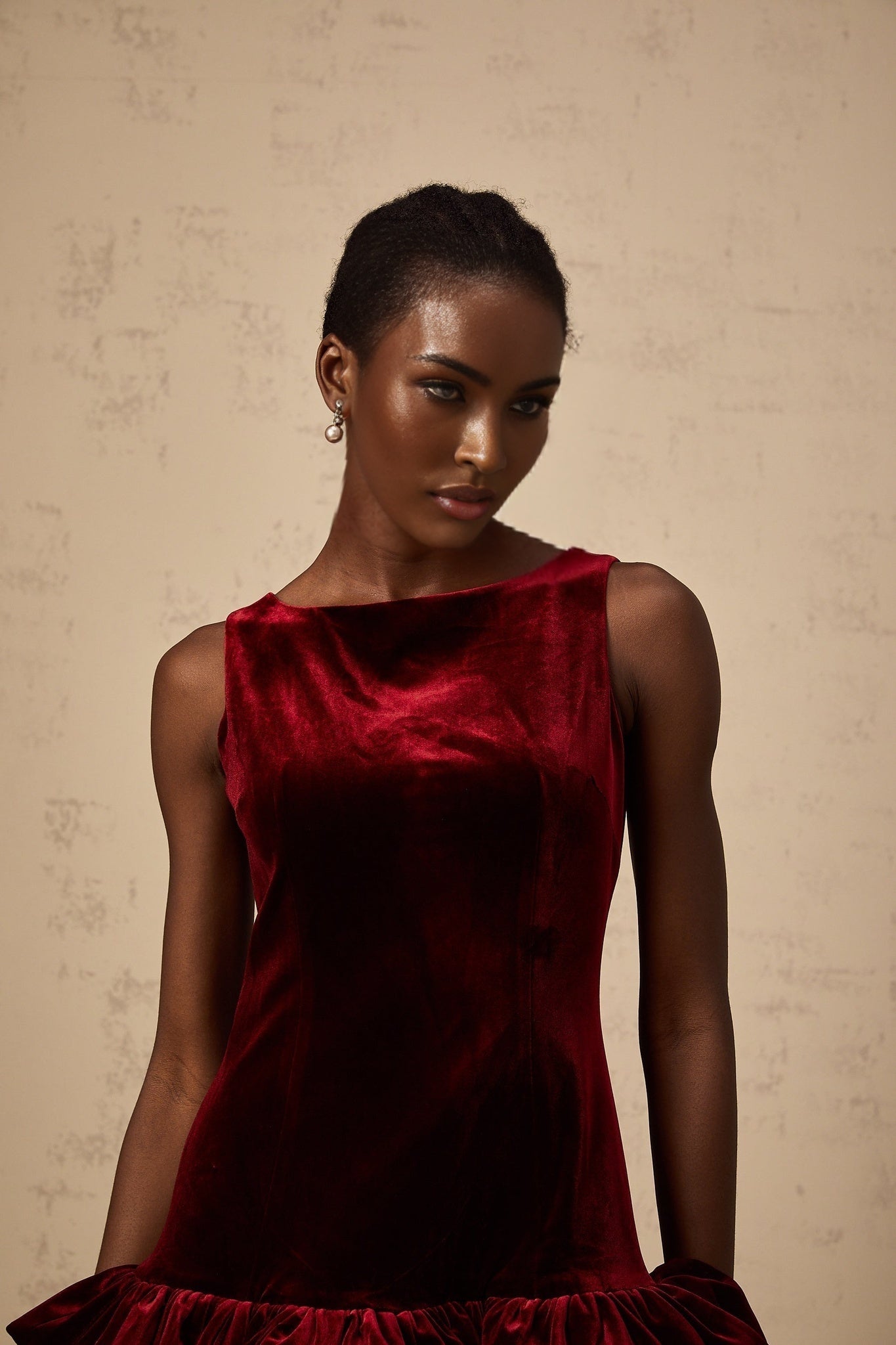 A short red velvet dress with a peplum hem detail and mini length
