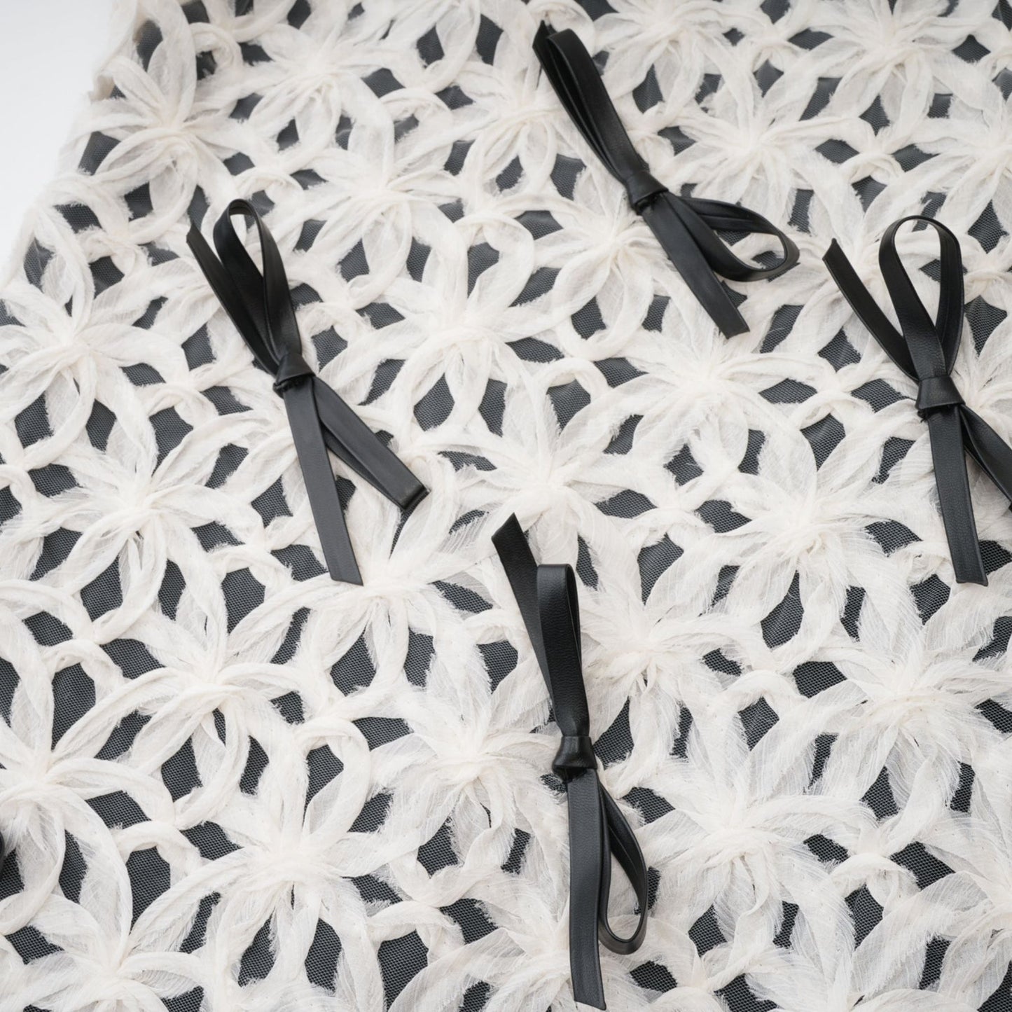 Monochrome dress with a bow and braided pattern partially transparent %backside zipper thigh length 67% Cotton 33% Polyester