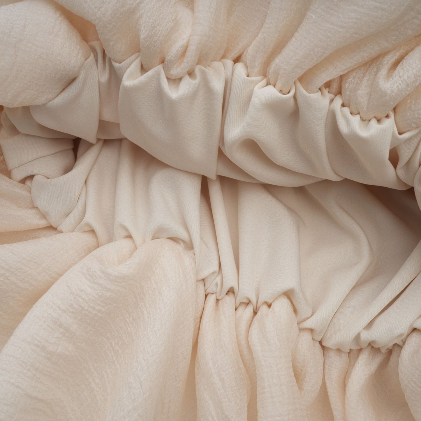 A short tiered mini dress in neutral tones featuring delicate floral applique details named Zephyrine