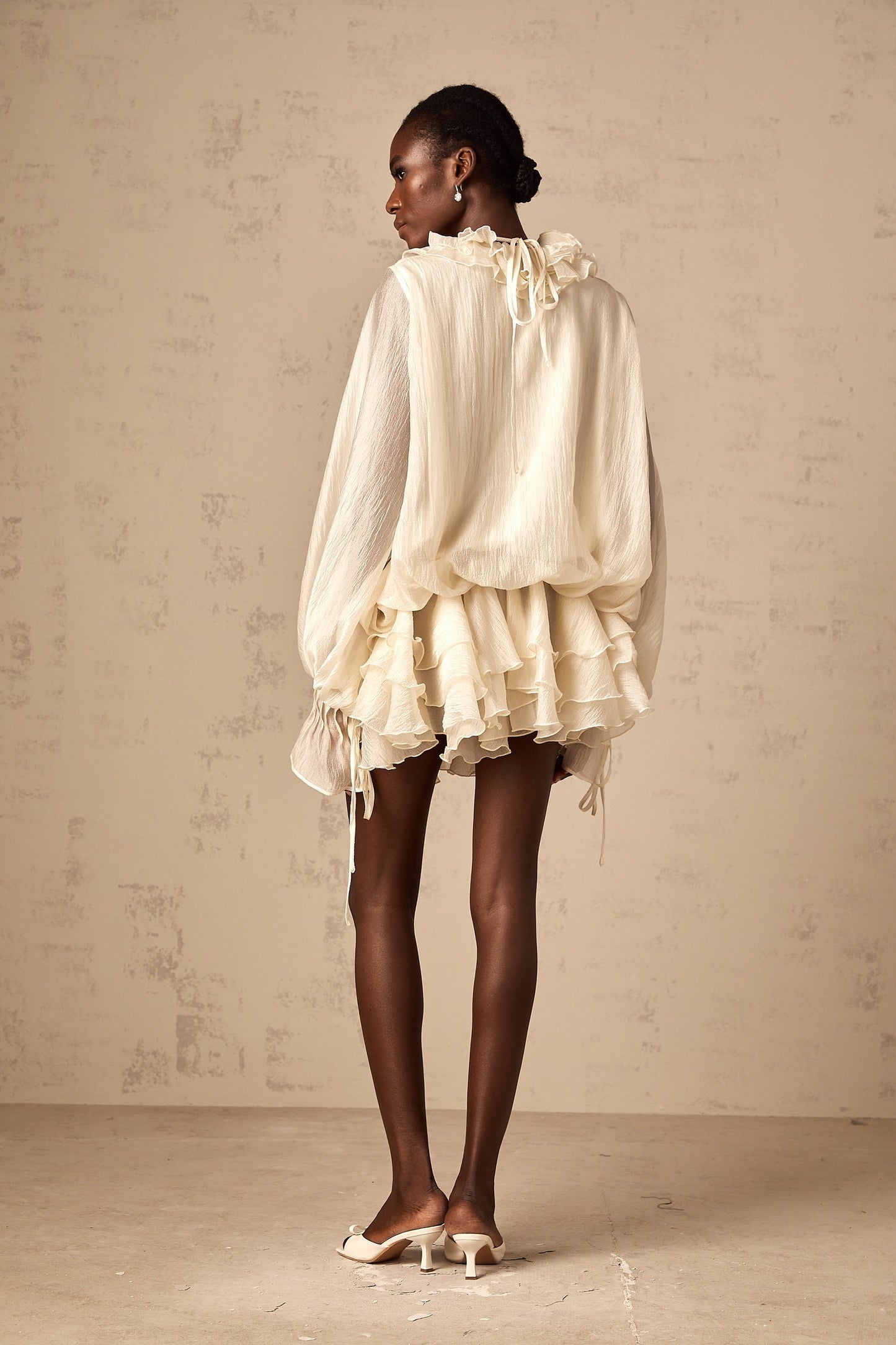 A short tiered mini dress in neutral tones with floral applique details called Zephyrine