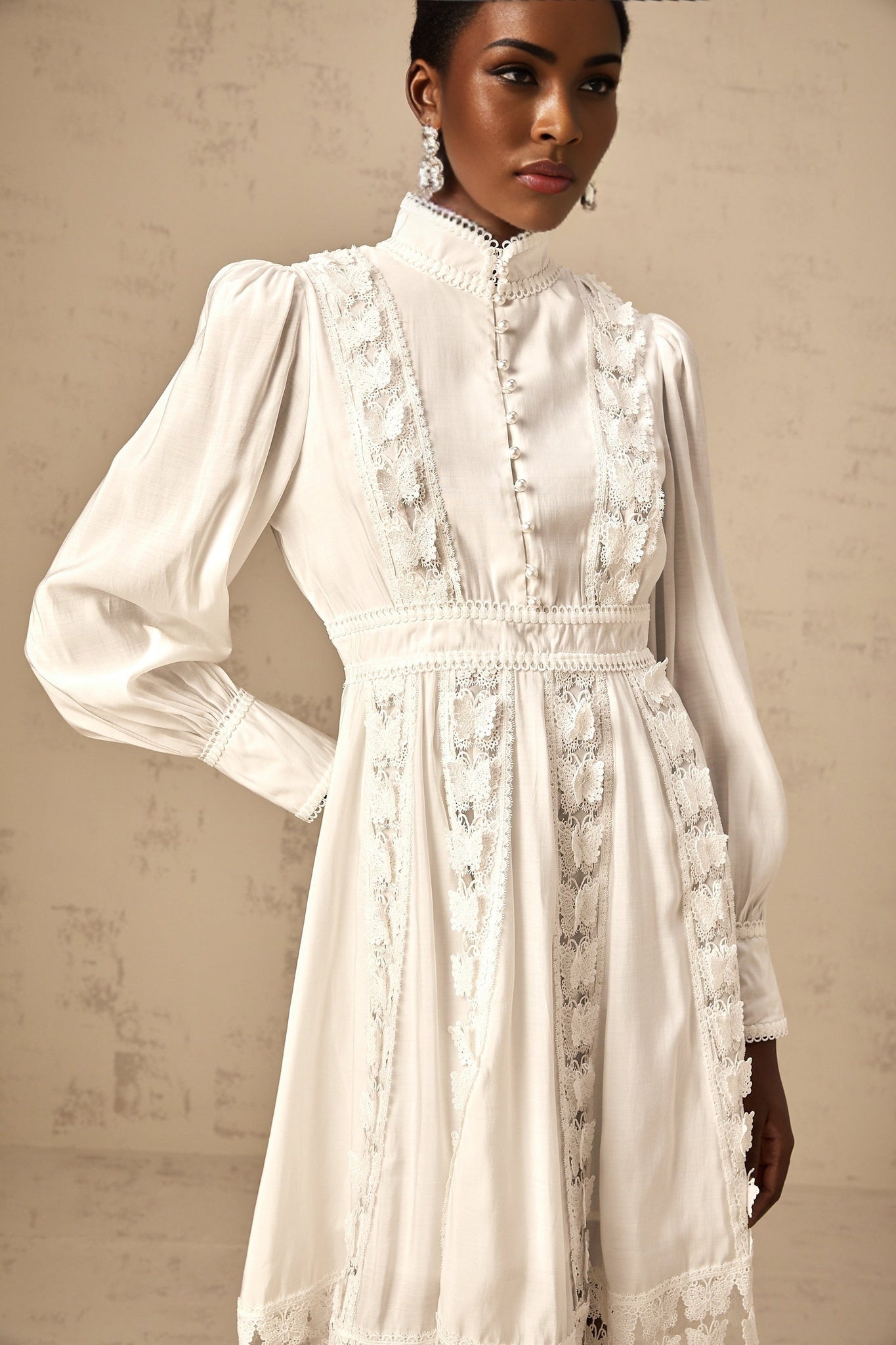A short white dress with butterfly appliques adorning the fabric