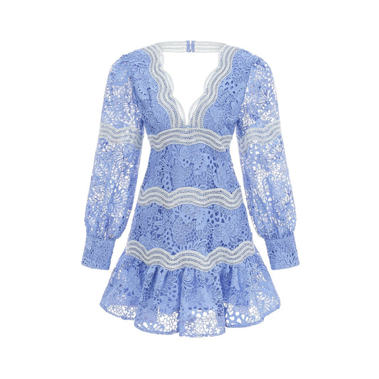 A short white dress with floral embroidery featuring a V neckline and a mini length skirt