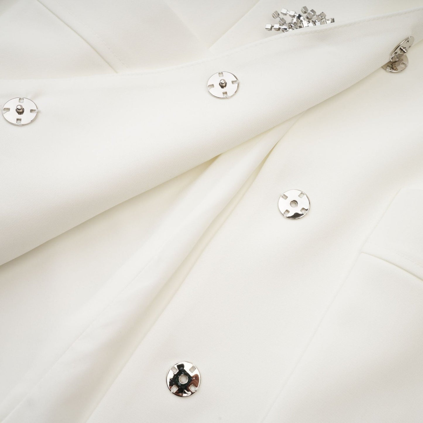 A short white mini dress adorned with crystal embellishments featuring a sleek and elegant design