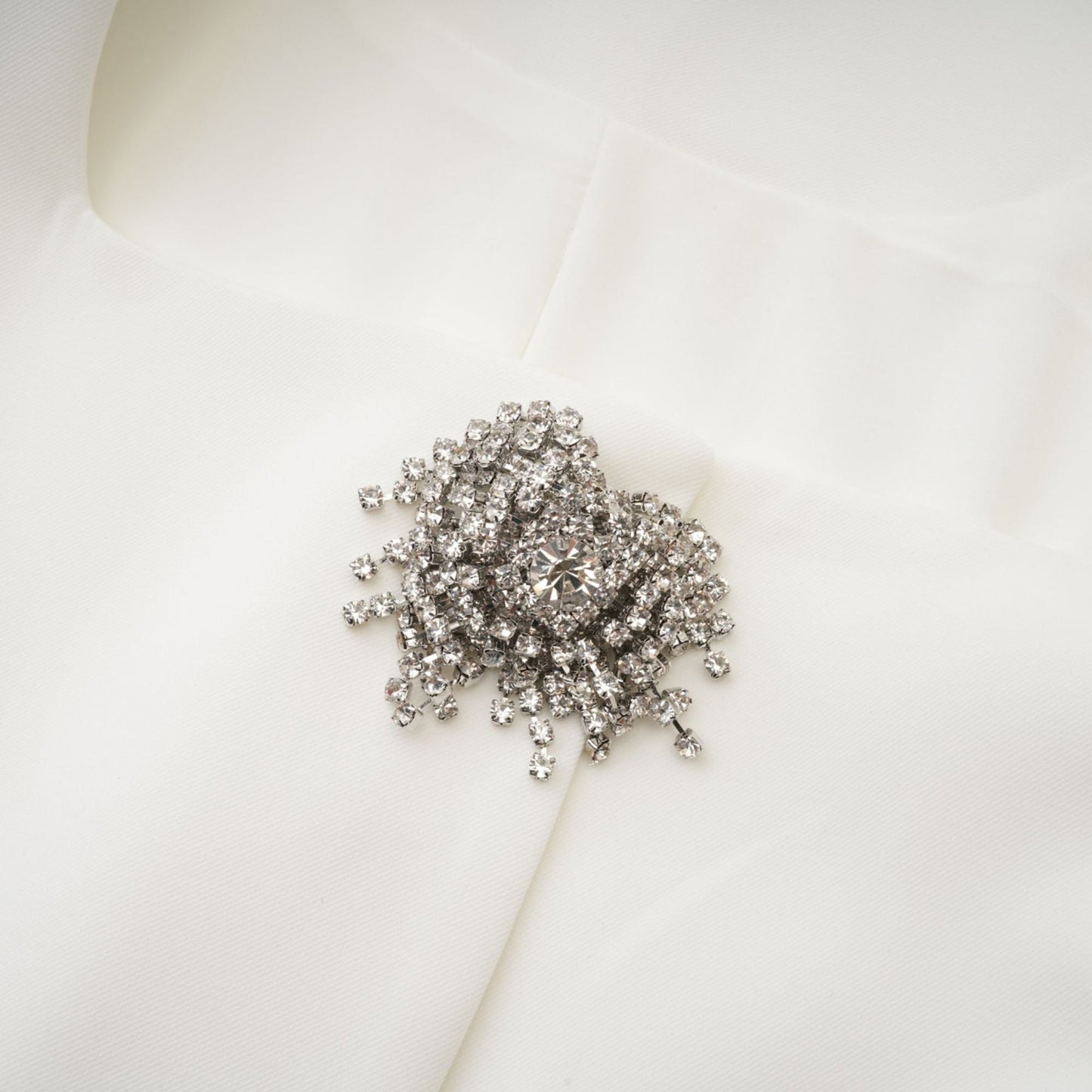 A short white mini dress adorned with crystal embellishments featuring a sleek and elegant design