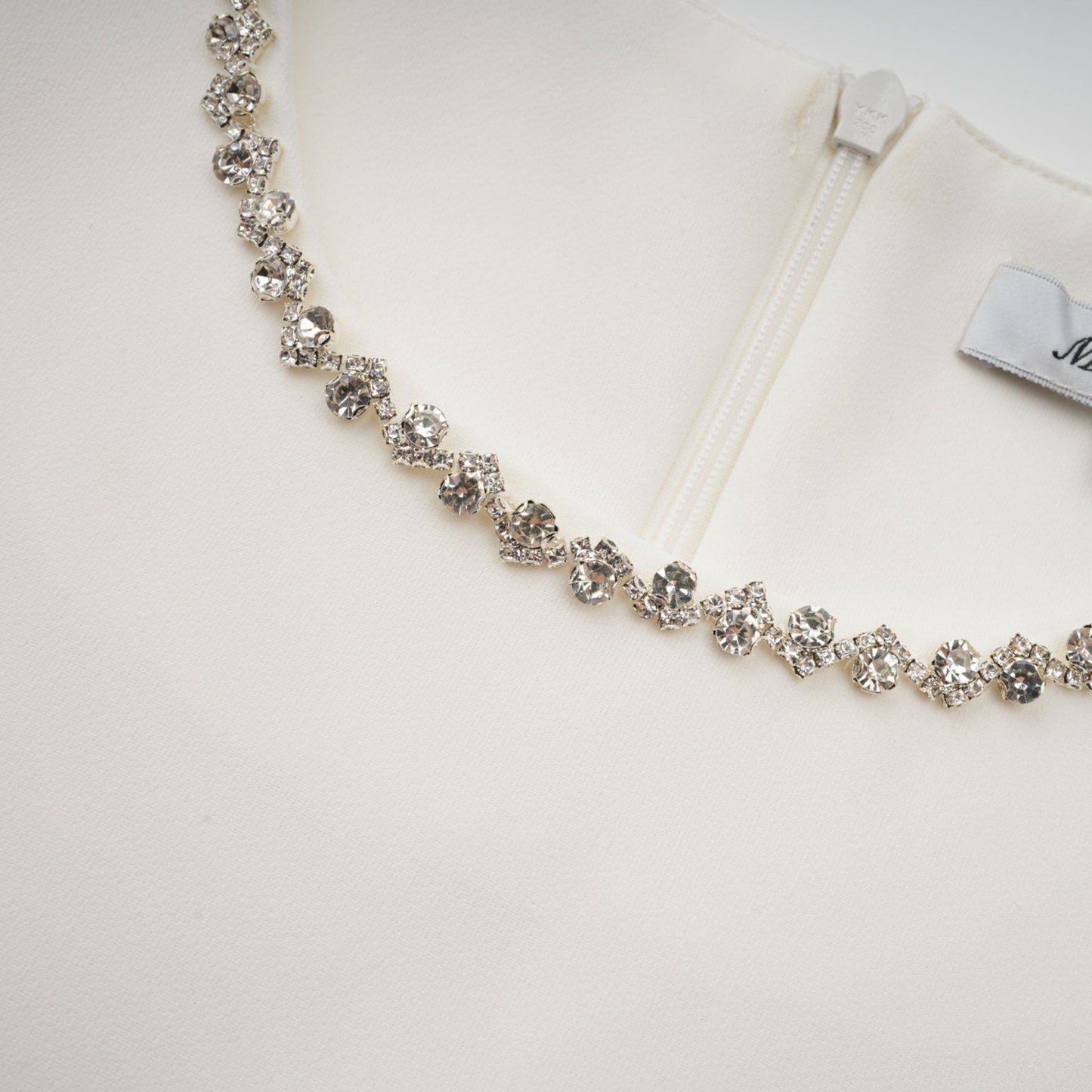 A short white mini dress adorned with crystal embellishments featuring a stylish design named Berenice